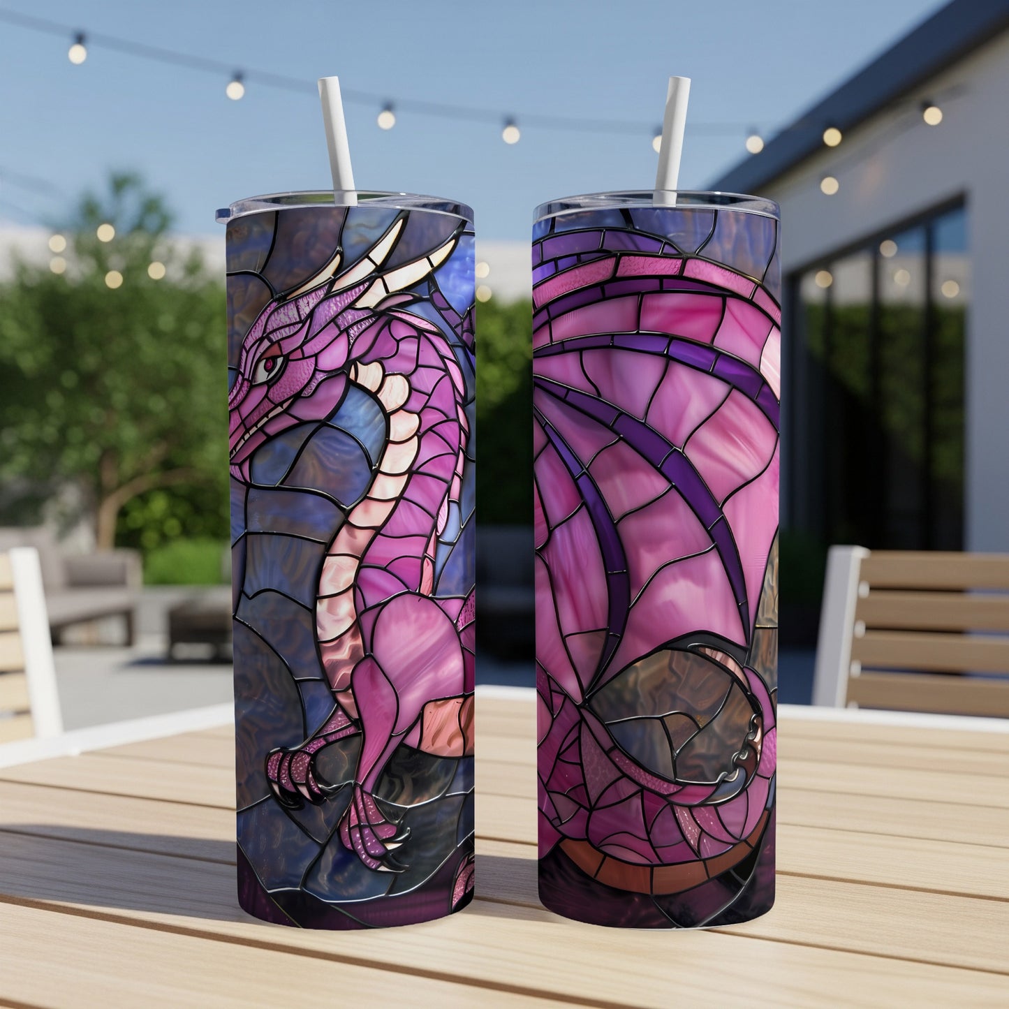 Two stained glass dragon tumblers with pink and purple hues on a table.