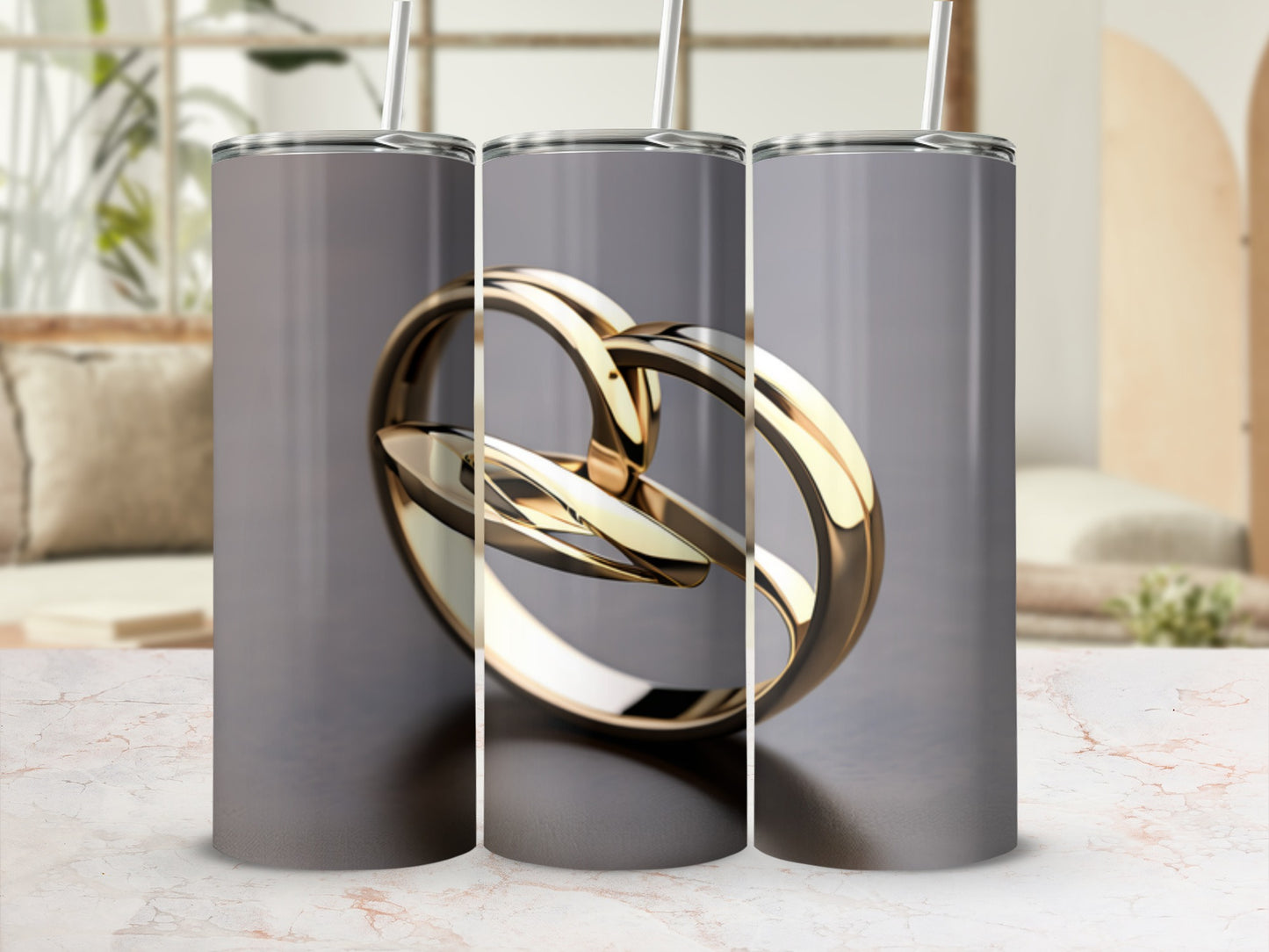 Three tumblers showing a gold interlocking ring design on a marble surface.