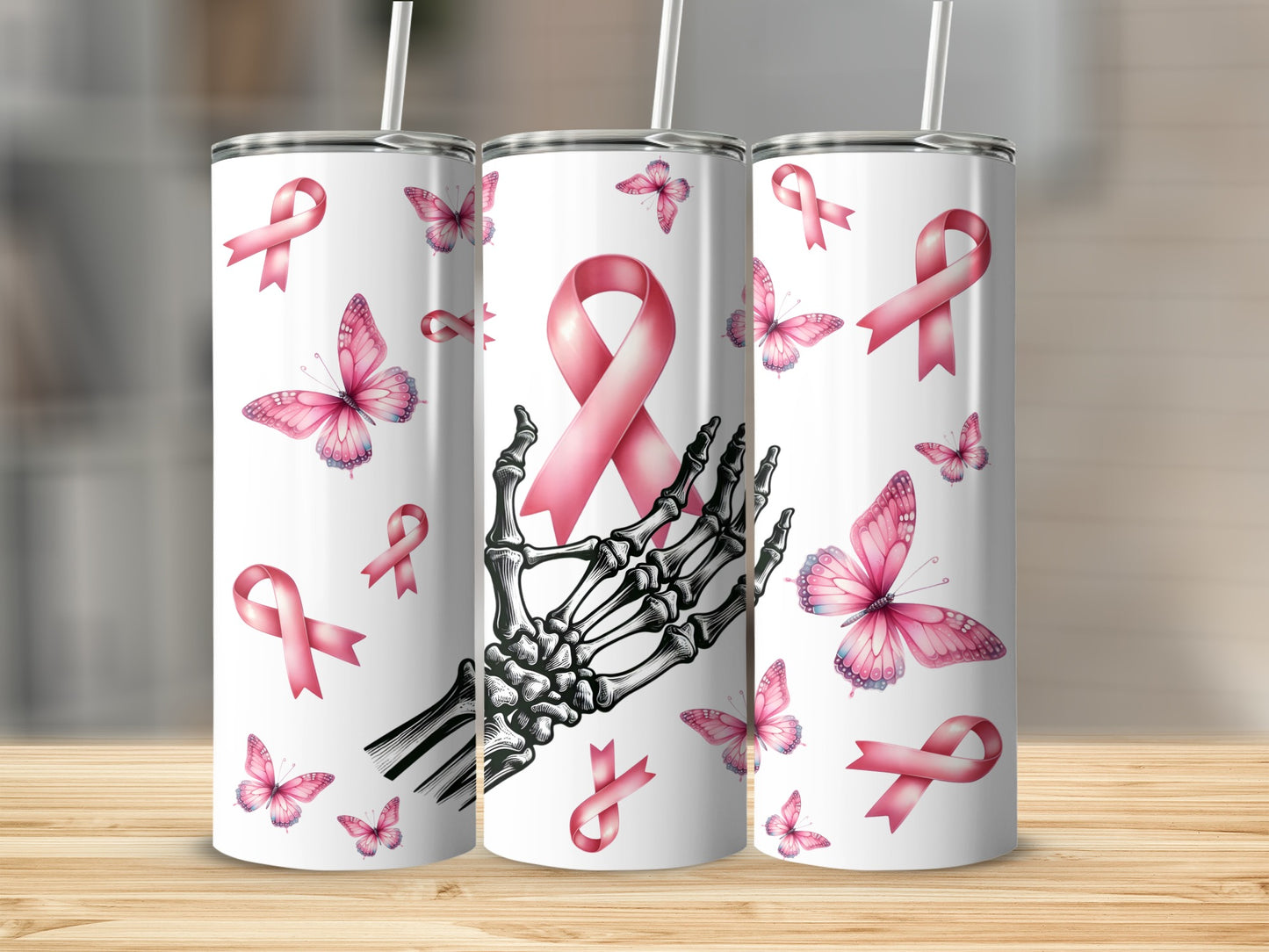 Three tumblers with pink ribbons and butterflies, one with a skeleton hand.