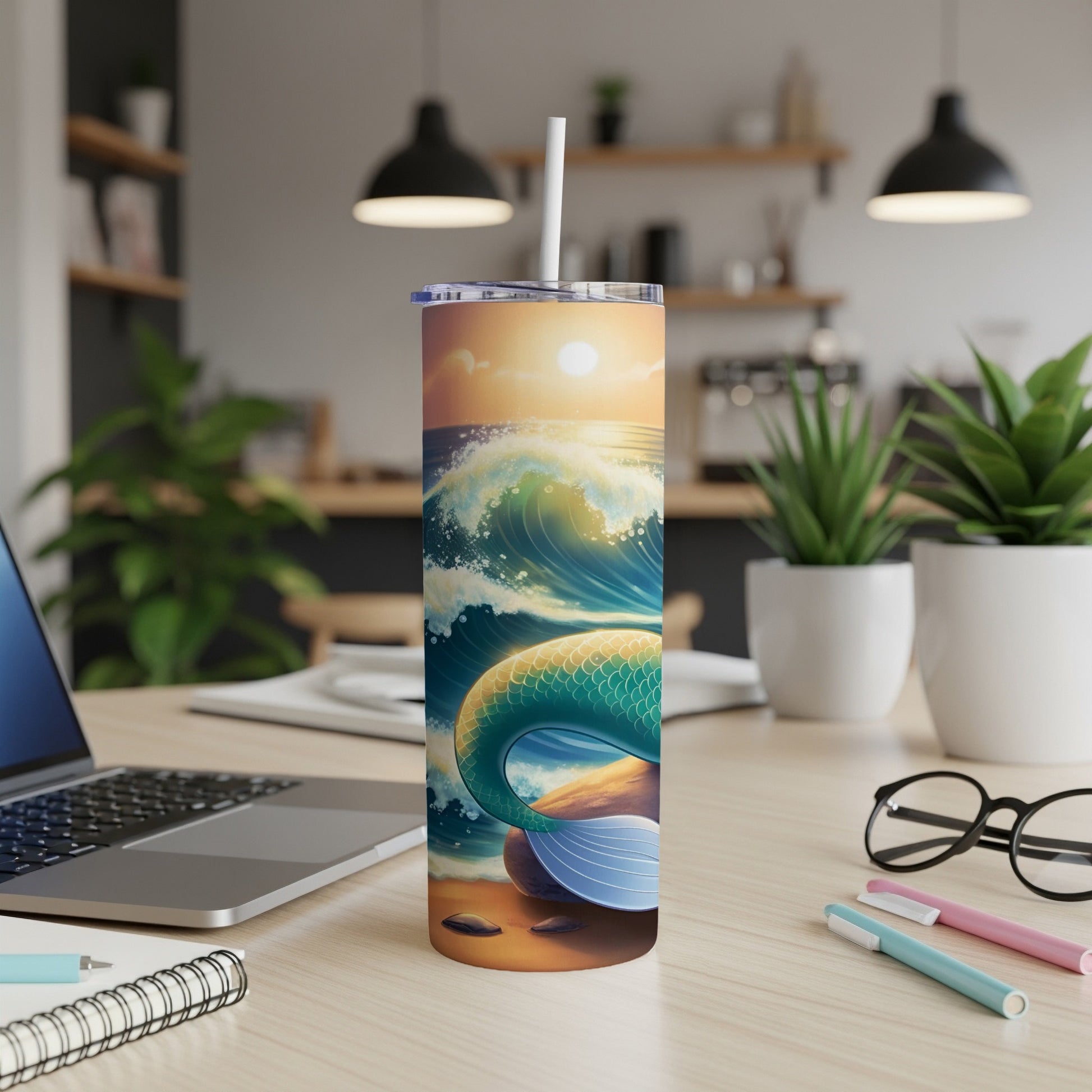 Mermaid tail and ocean waves on a tumbler with a straw, on a desk.