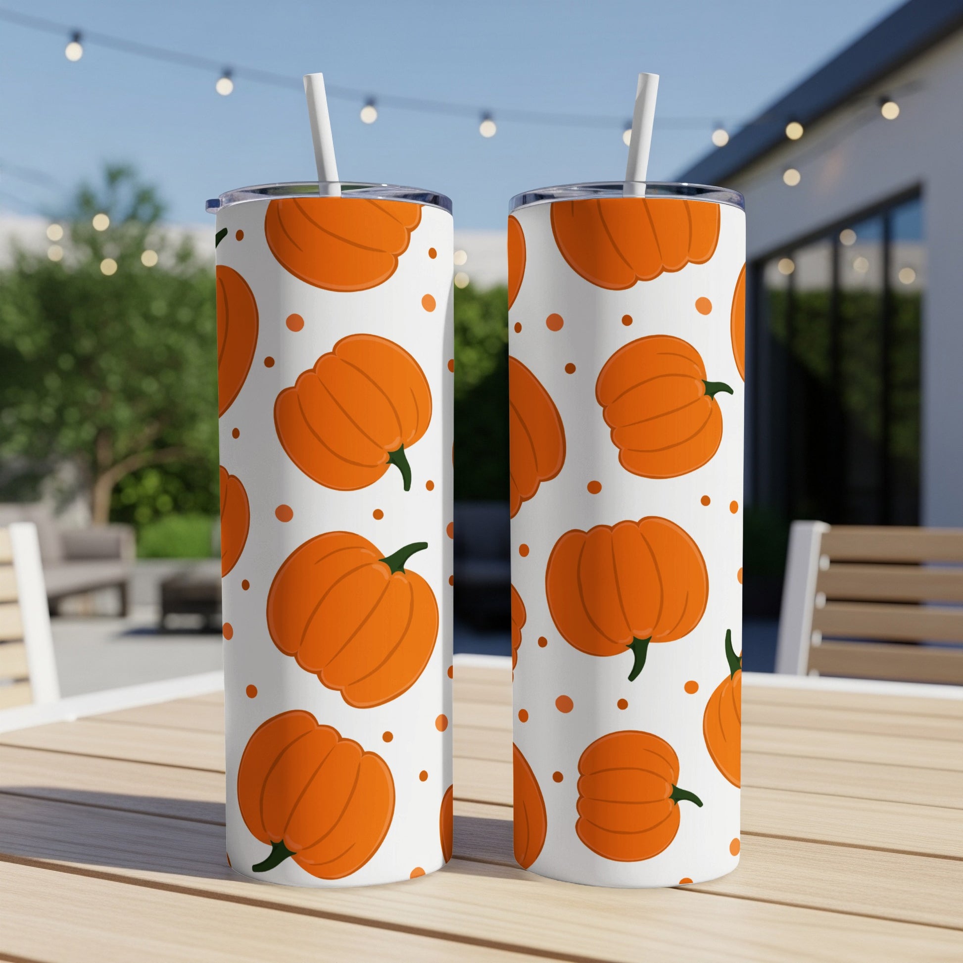 Two white tumblers with orange pumpkins and white polka dots.