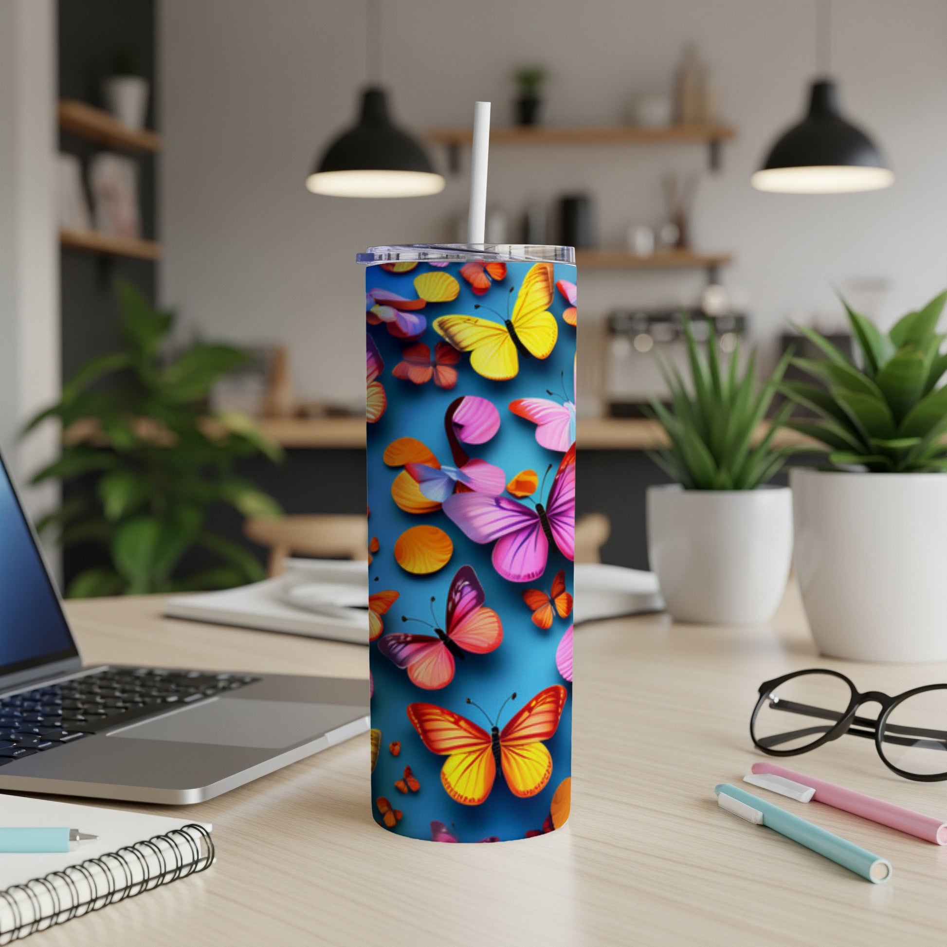 Tall tumbler with colorful butterflies and orange circles on a blue background.