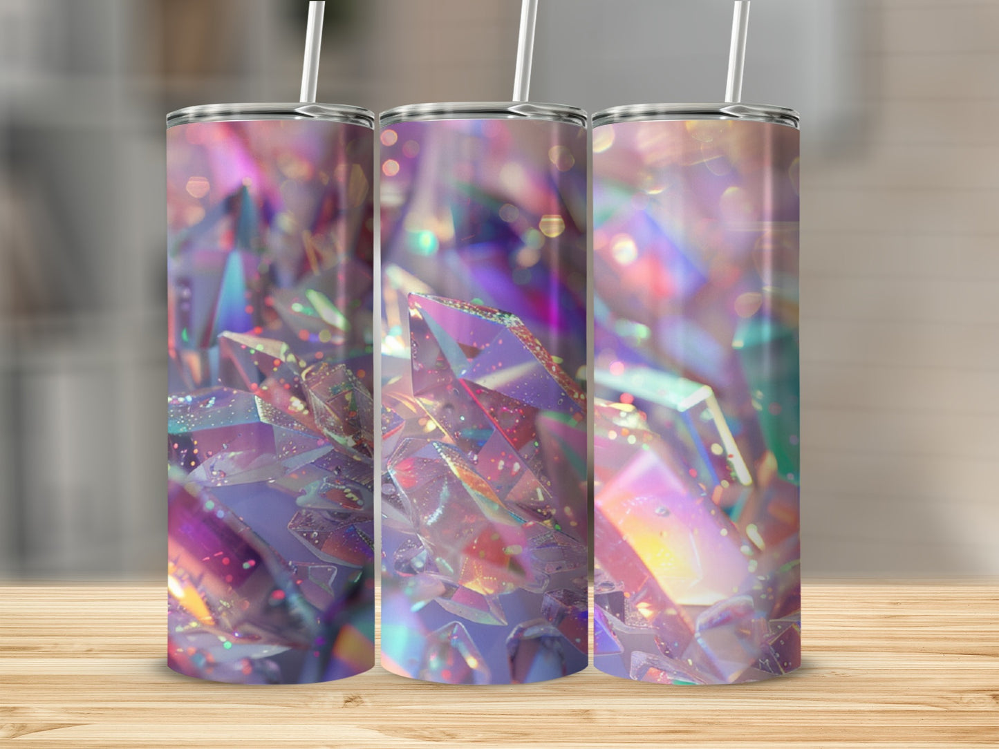 Three tumblers with a holographic crystal design, on a wooden surface.