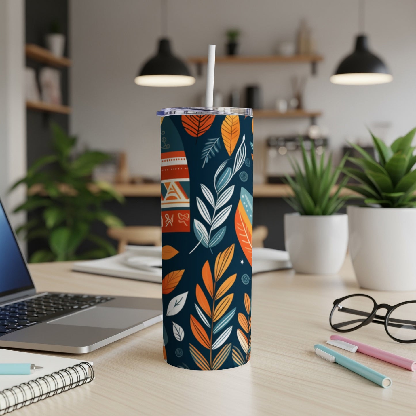 Dark blue tumbler with colorful leaf pattern and white straw.
