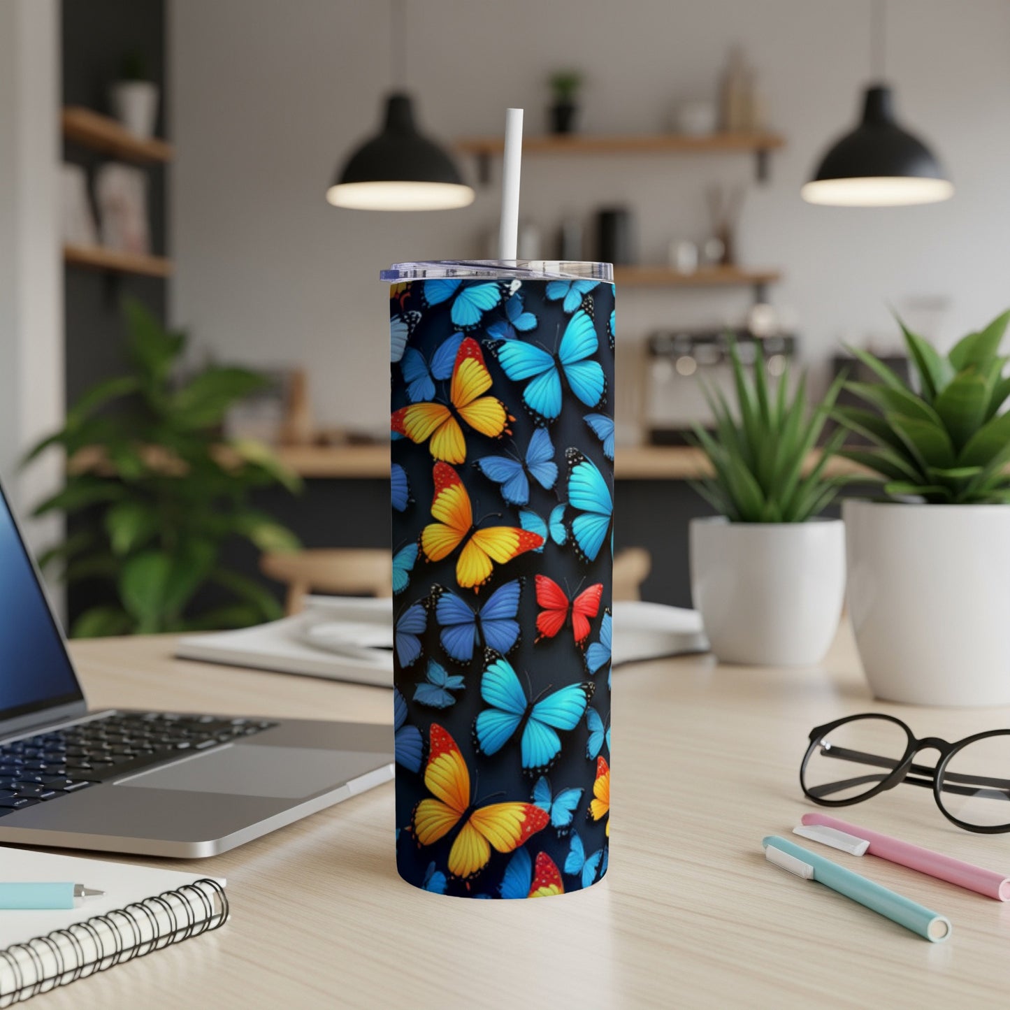 Tall tumbler with a colorful butterfly pattern on a desk.