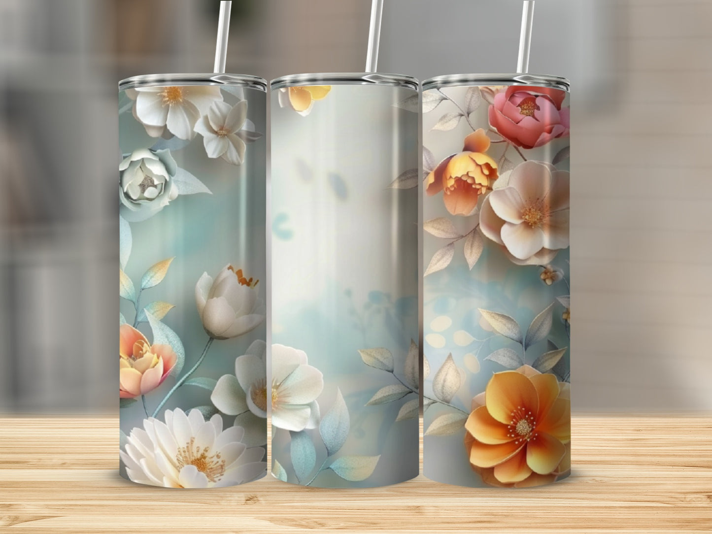 Three tumblers with a floral design on a wooden surface.
