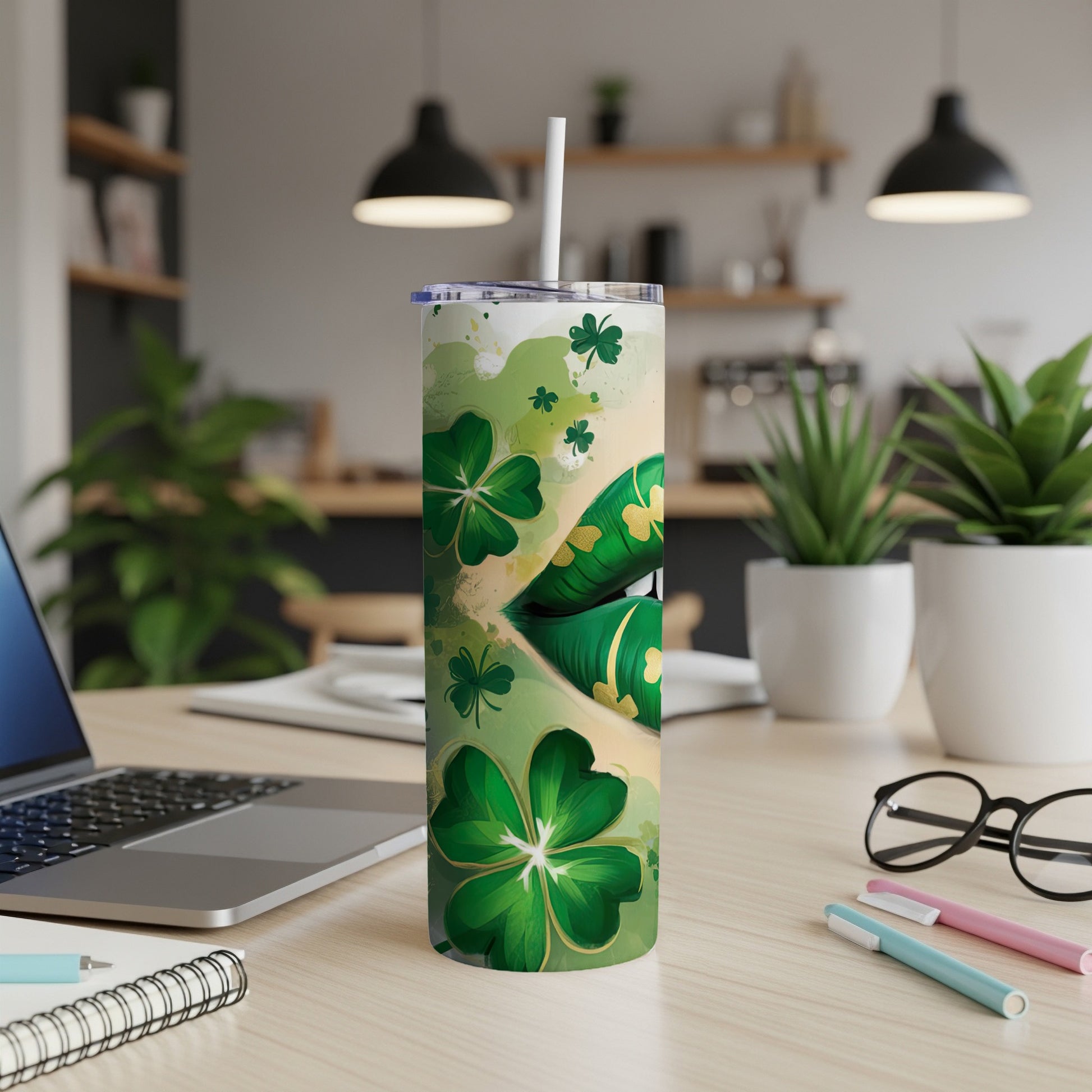 Green tumbler with shamrocks and gold accents, on a desk.