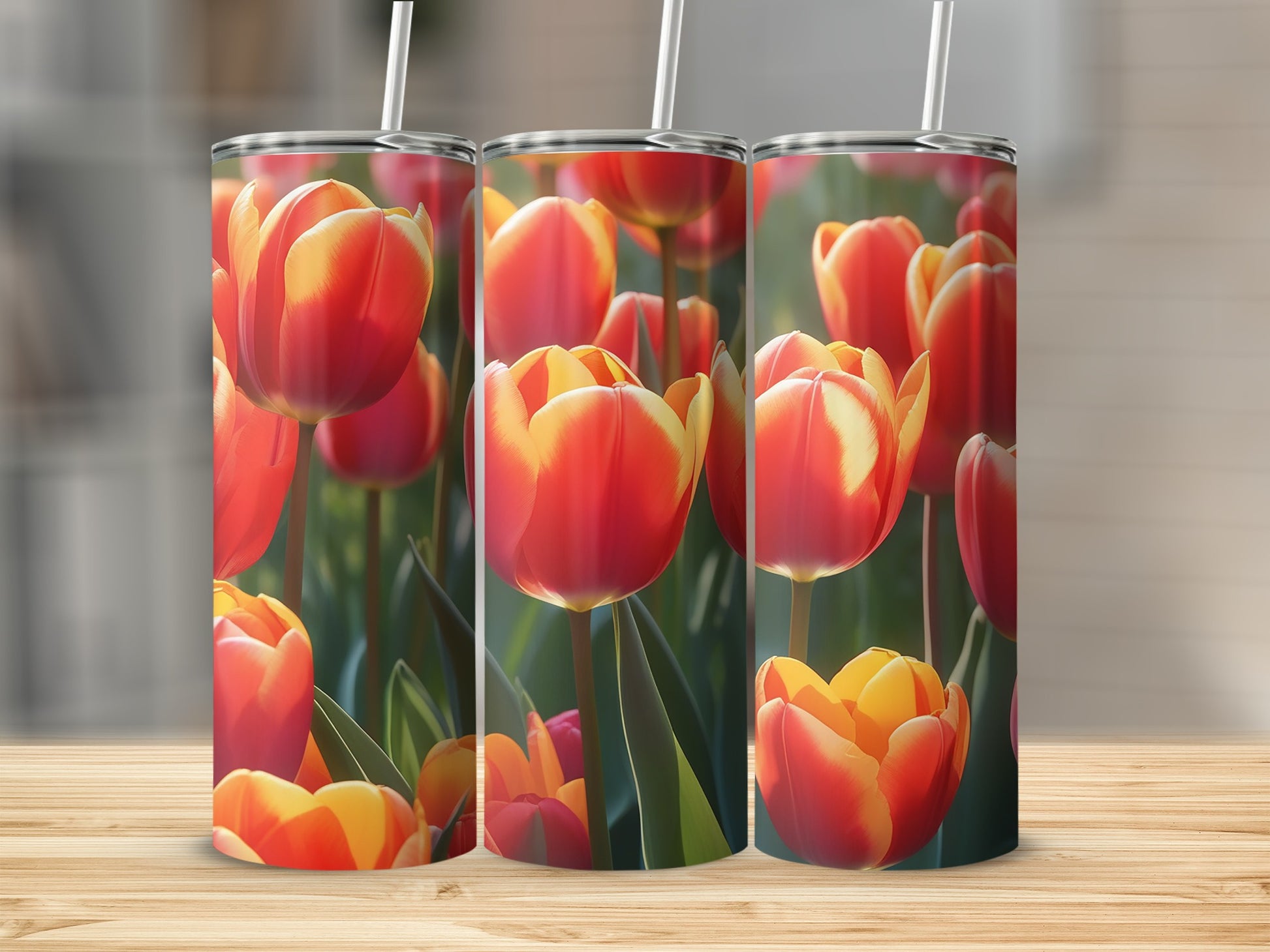 Three tumblers decorated with red and yellow tulips and green stems.