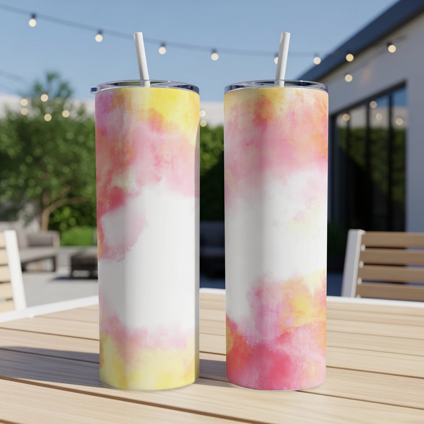 Two tumblers with a pink and yellow tie-dye pattern sit on a wooden table.