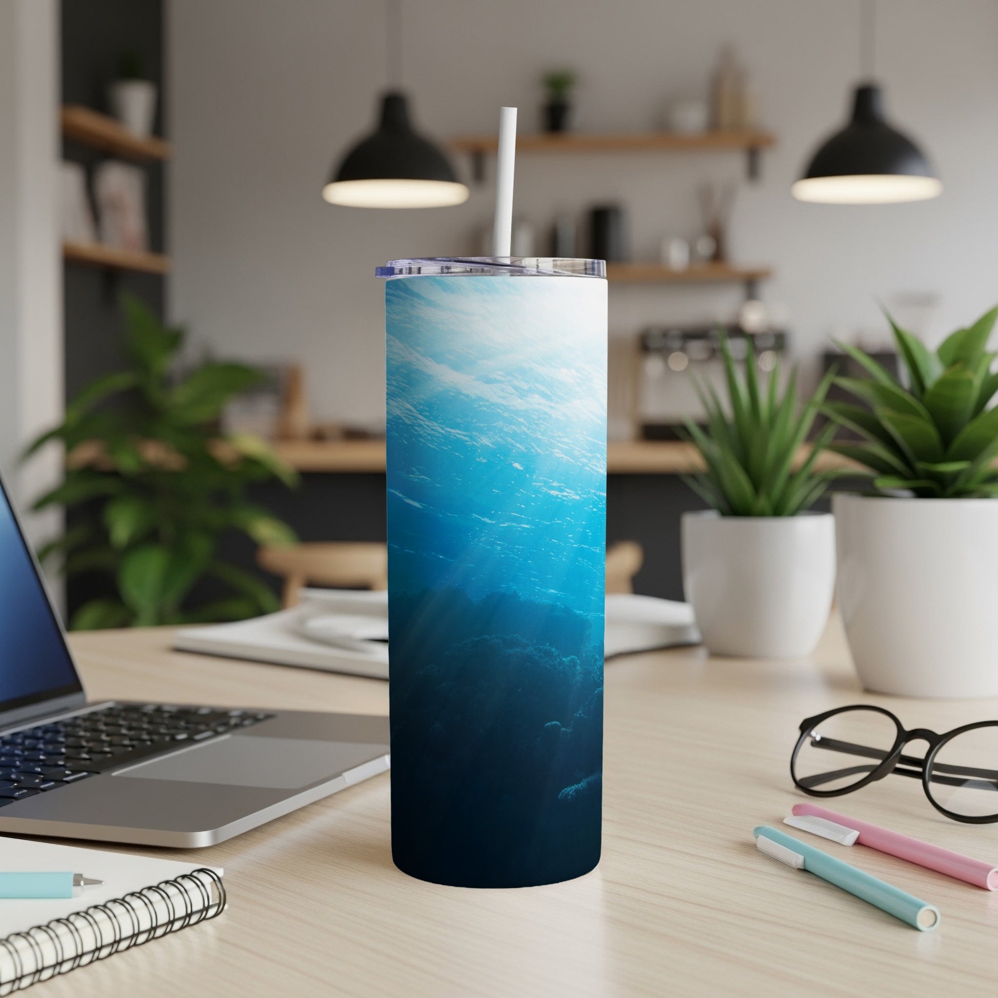 Ocean depths with sunbeams piercing the water on a blue tumbler.