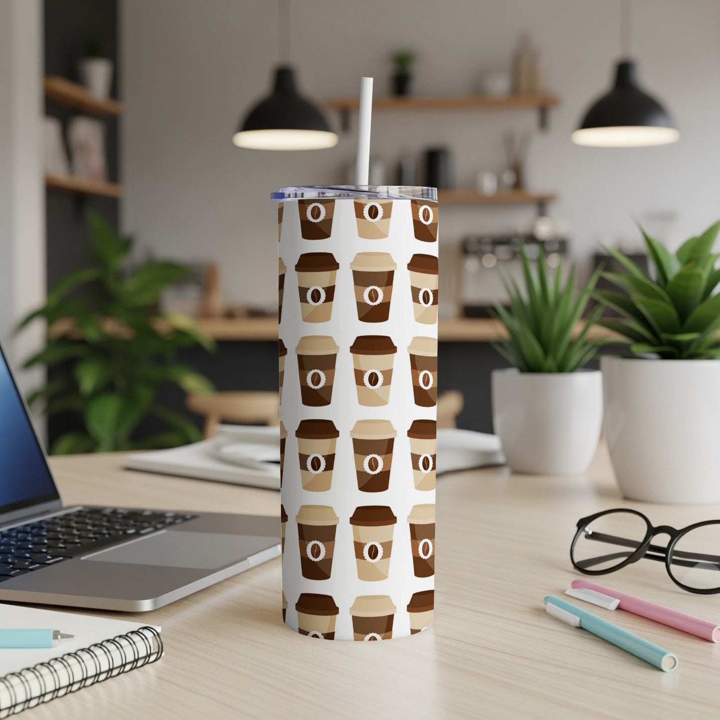 Tall tumbler with repeating coffee cup pattern and straw.