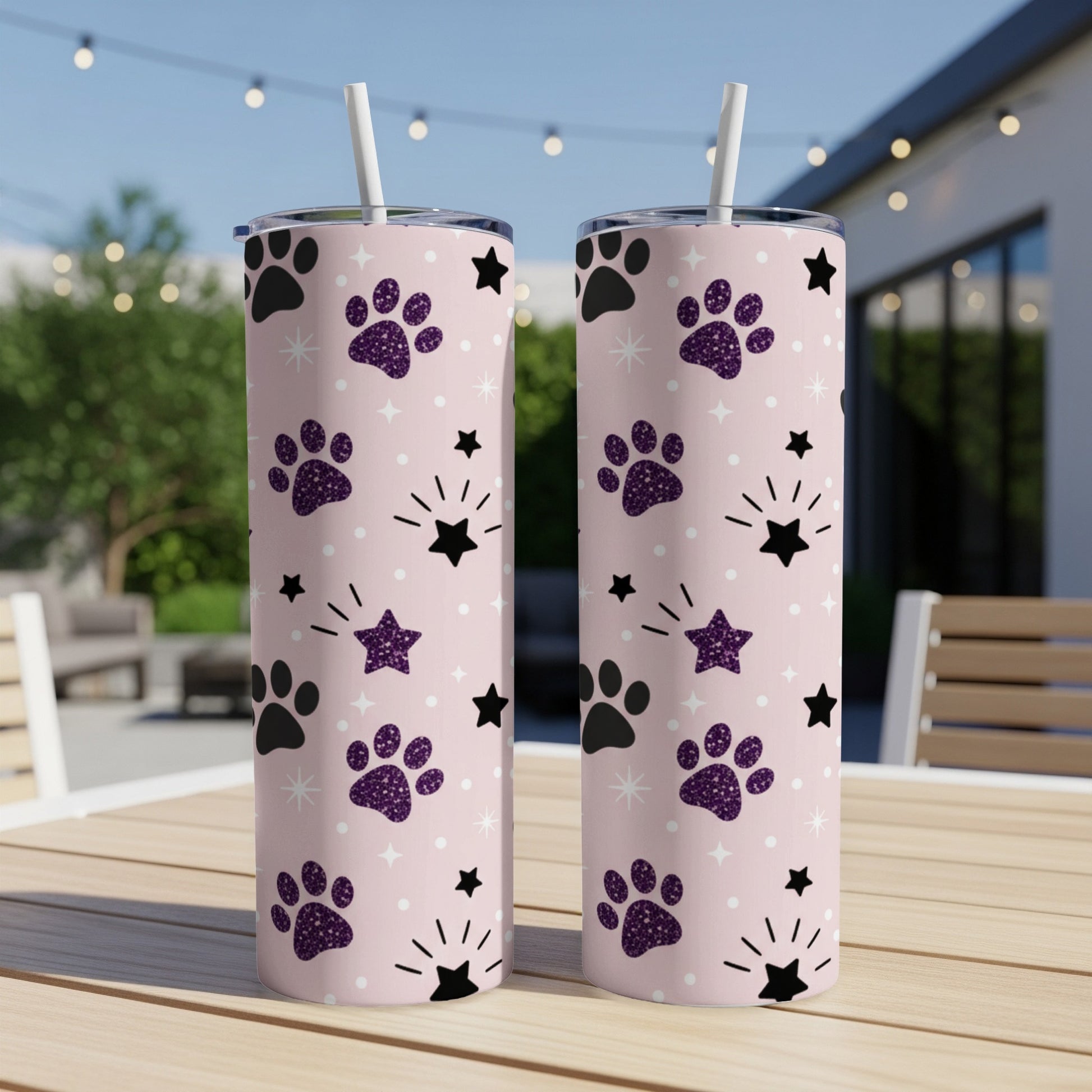 Two pink tumblers with purple paw print and star pattern.