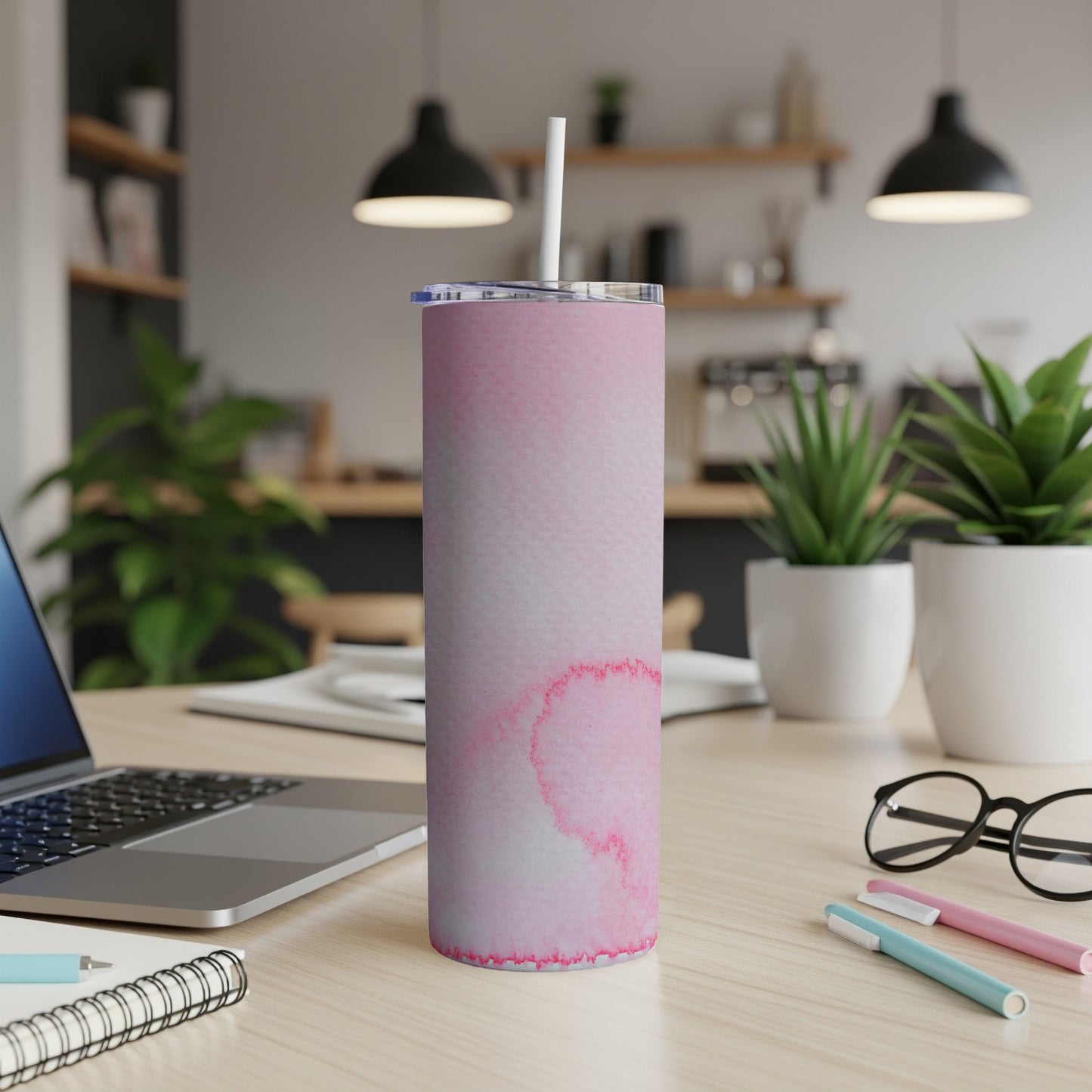 Pink watercolor tumbler with straw on a desk next to a laptop.