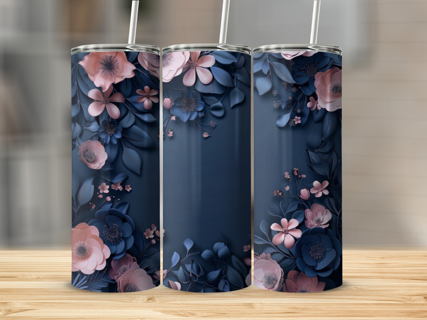 Three navy blue tumblers with floral designs on a wooden surface.