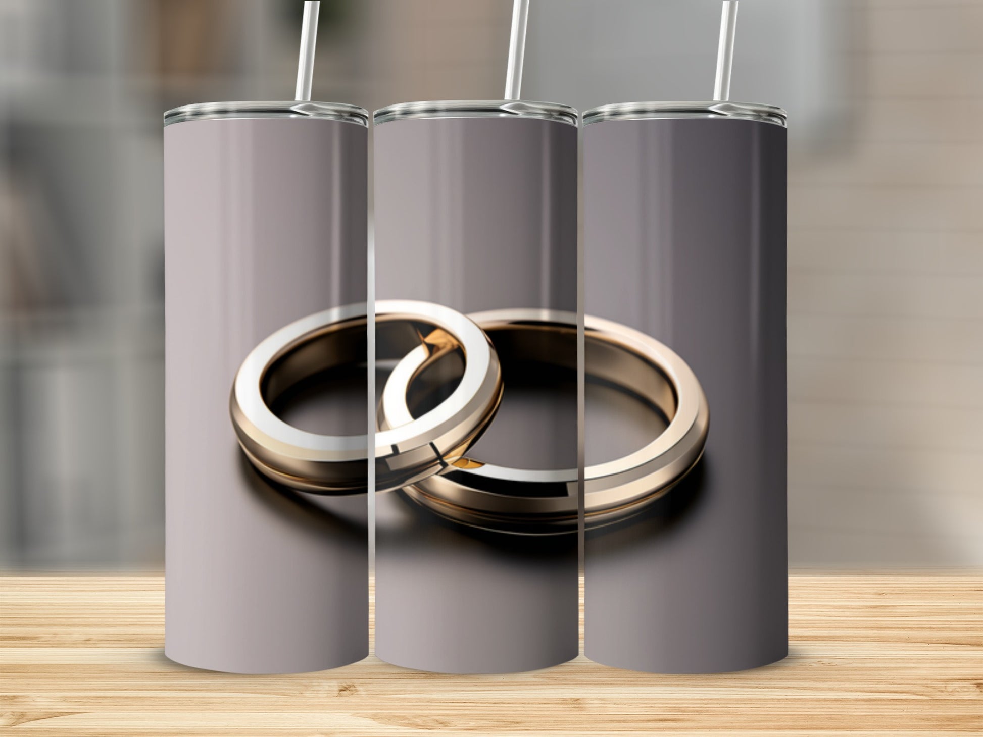 Two gold wedding rings with straws on a wooden surface.