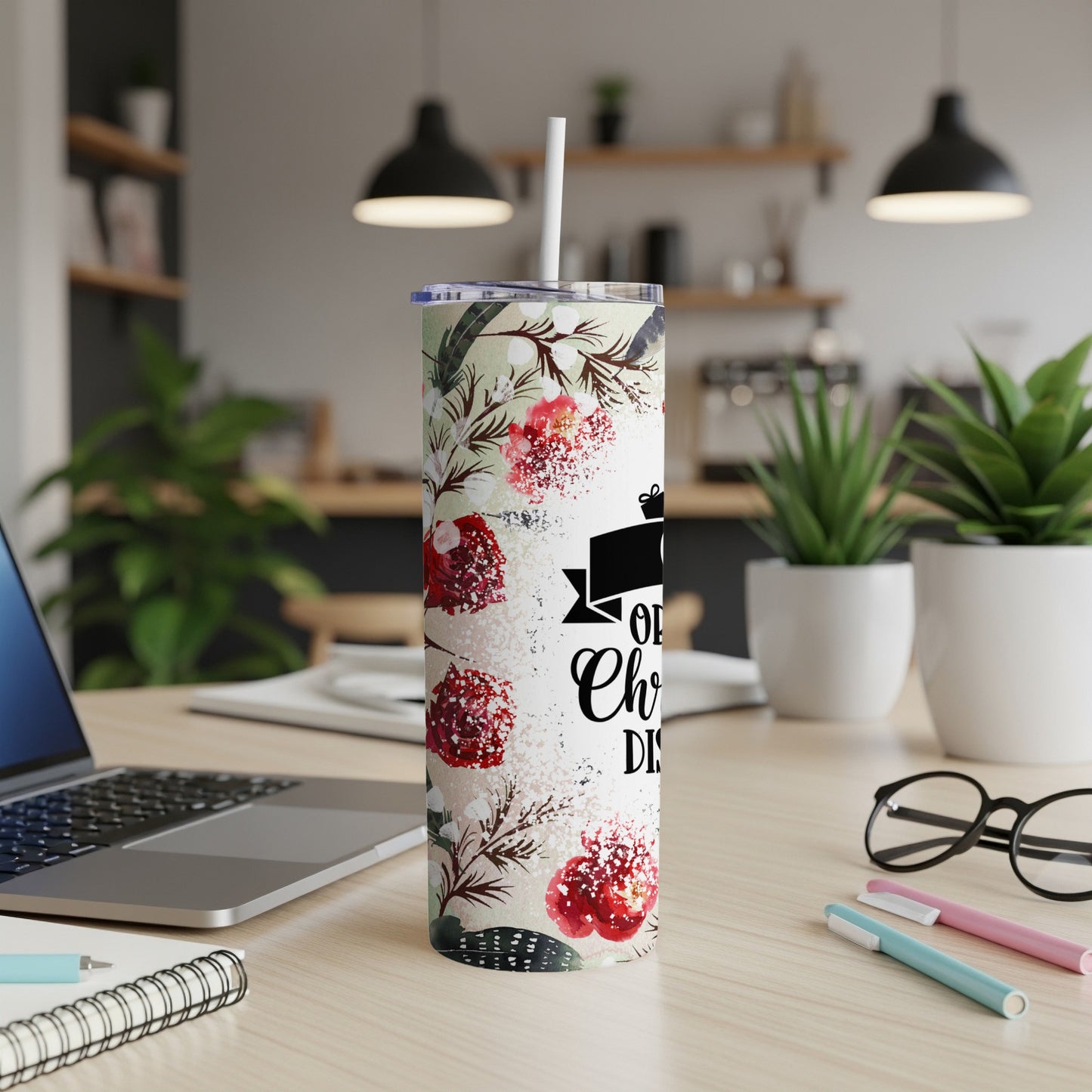 Floral tumbler with "Oh, Christmas Tree" text on a desk.