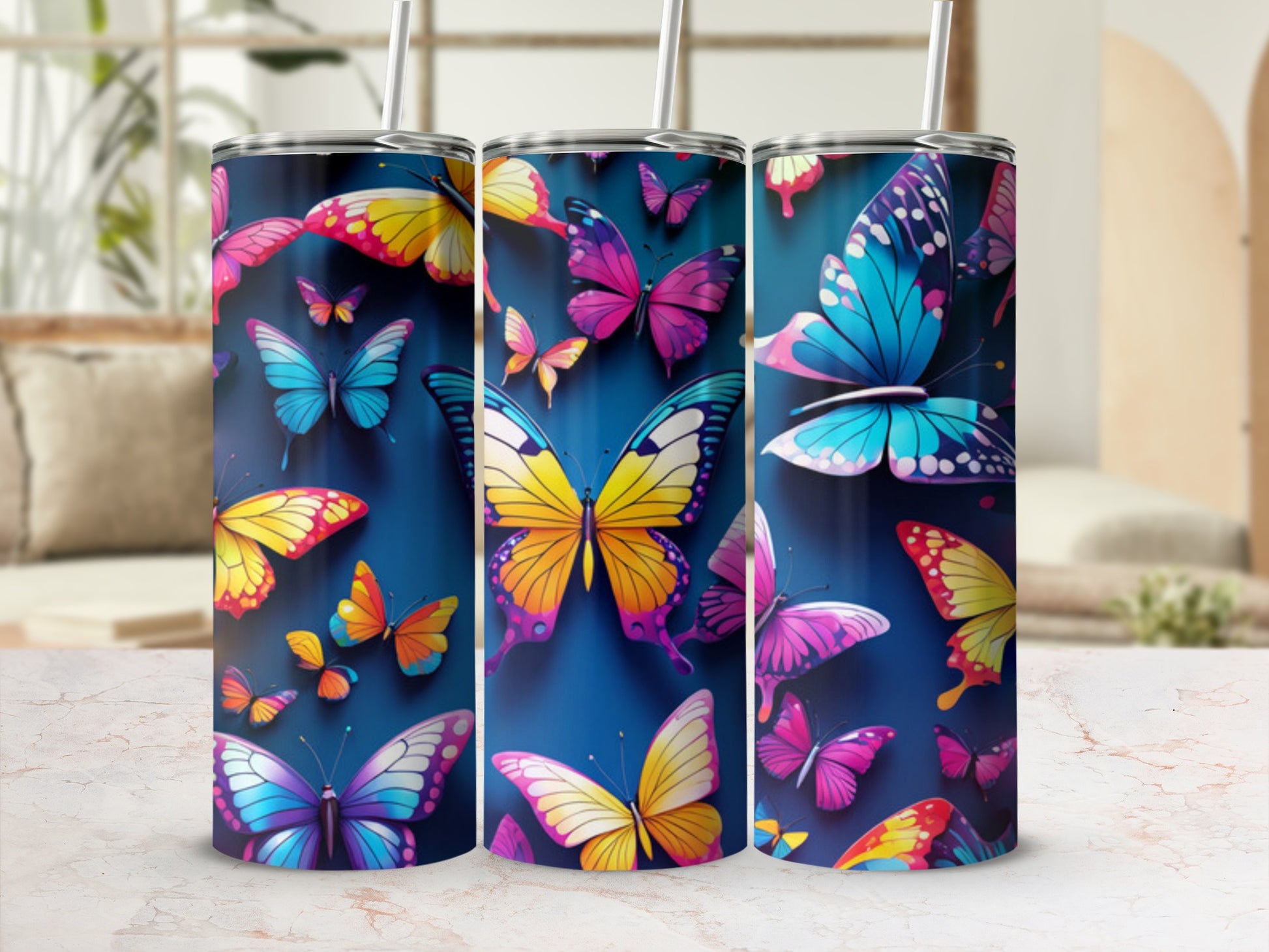 Two tall tumblers with vibrant butterfly designs on a marble surface.