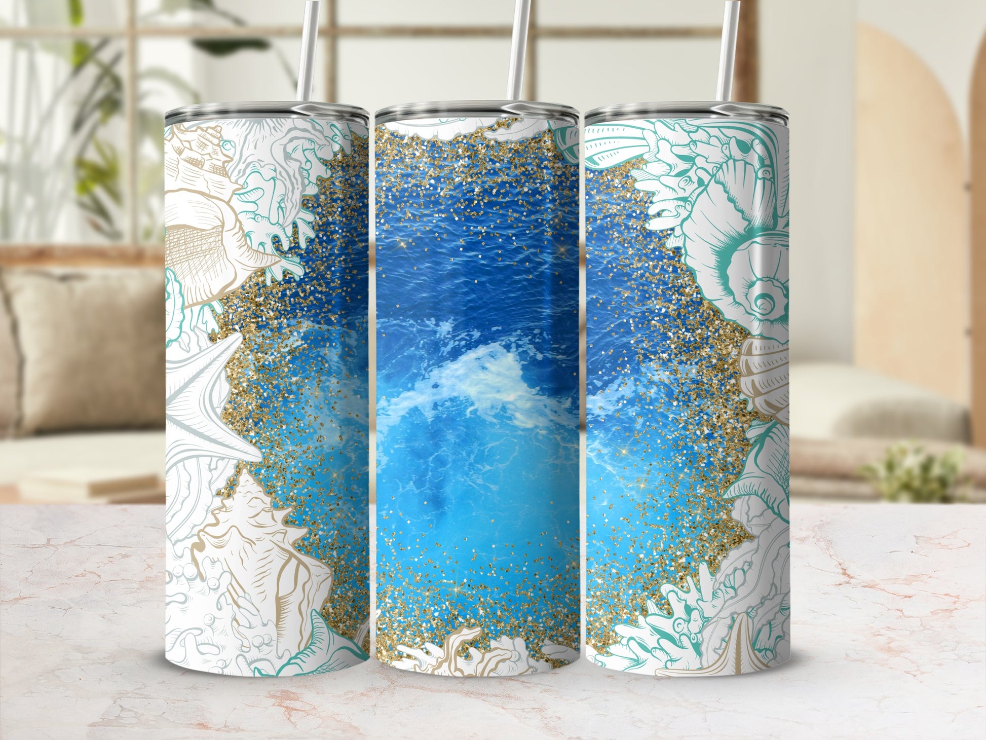 Three tumblers with seashell and ocean wave designs and gold glitter.