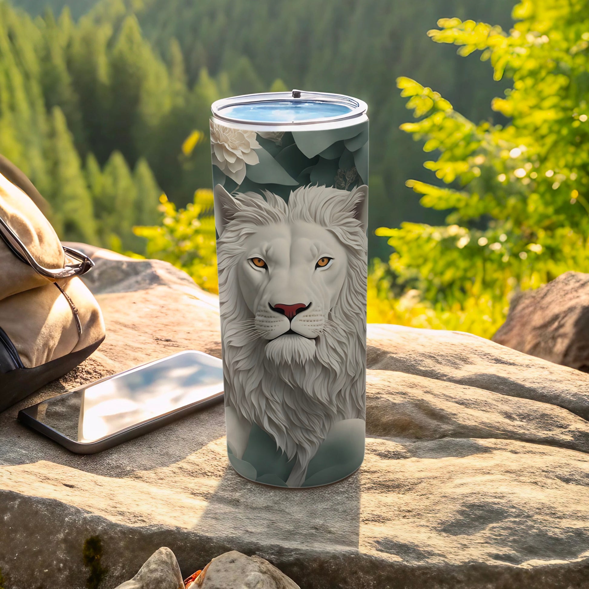 White lion portrait on a floral patterned tumbler with phone and backpack.