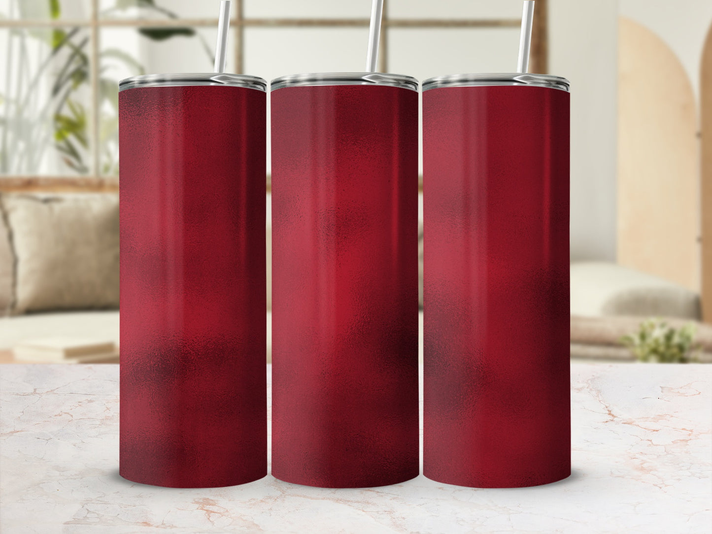 Three plain red tumblers with silver lids and straws on a marble surface.
