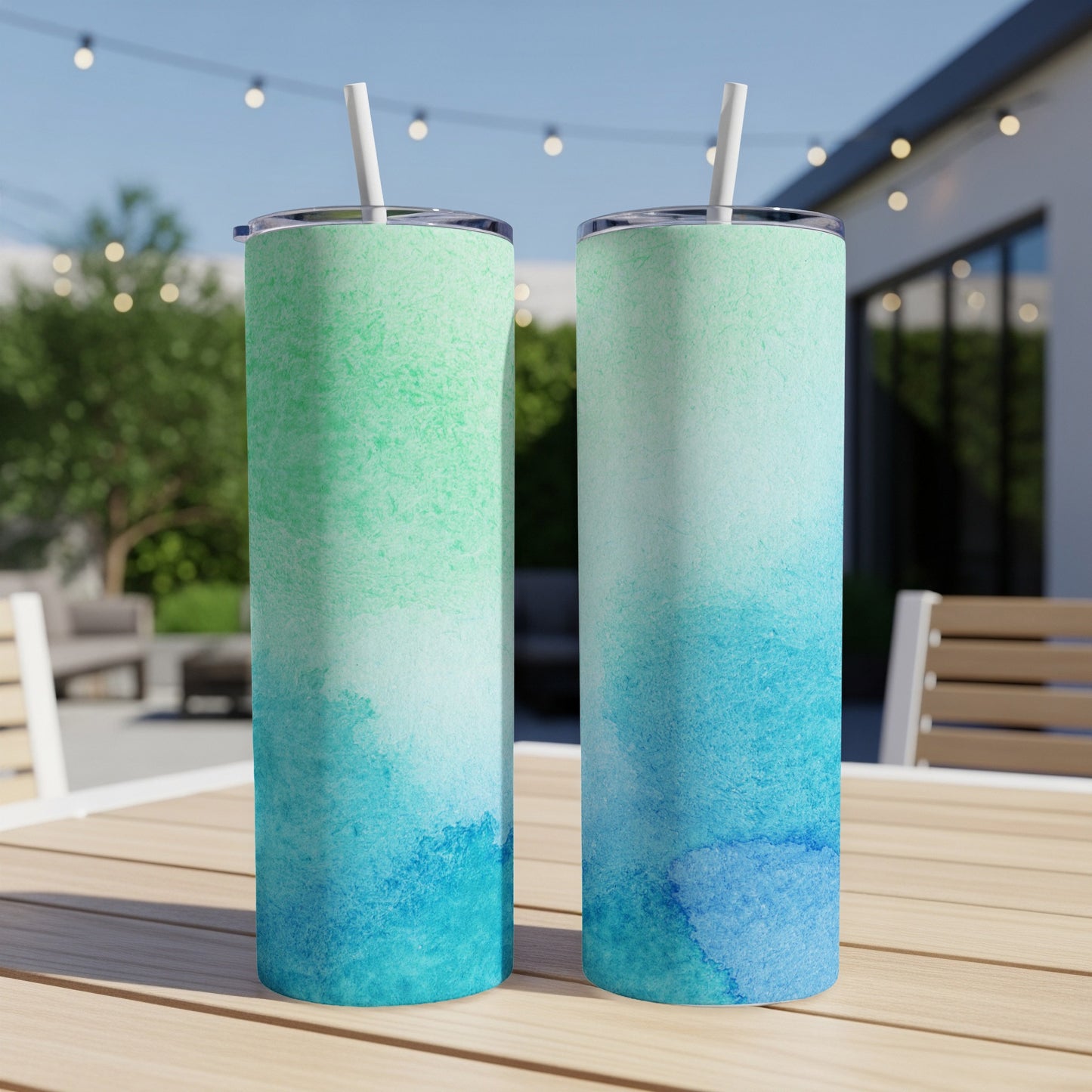 Two tall tumblers with watercolor blue and green ombre patterns.