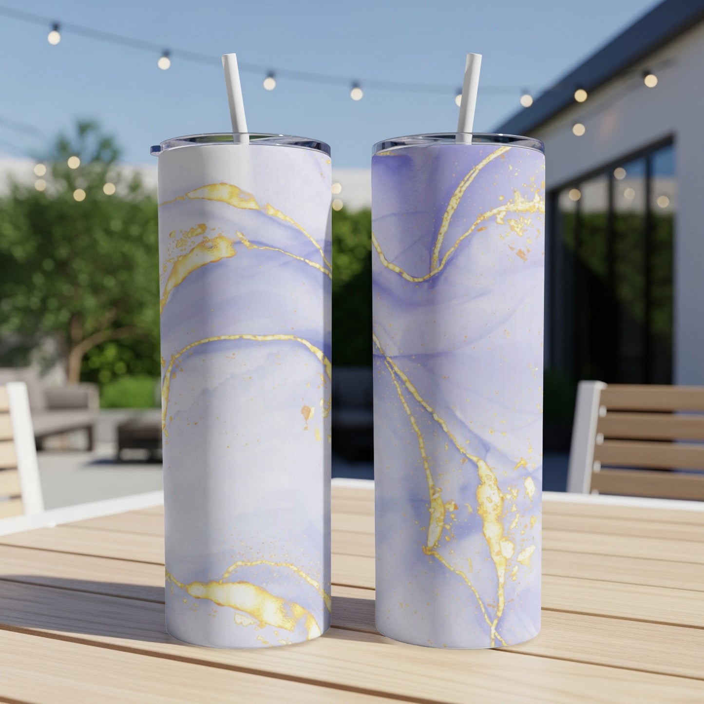 Two tall tumblers with purple and gold marbled pattern on a wooden table outdoors.