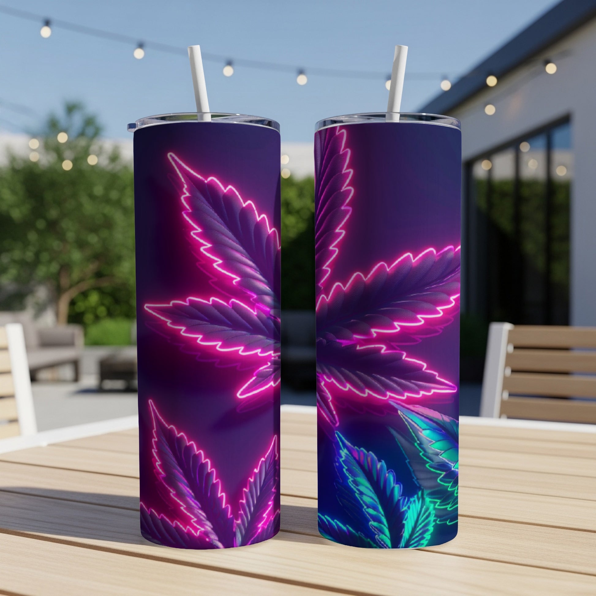 Two tumblers with neon cannabis leaf design on outdoor table.