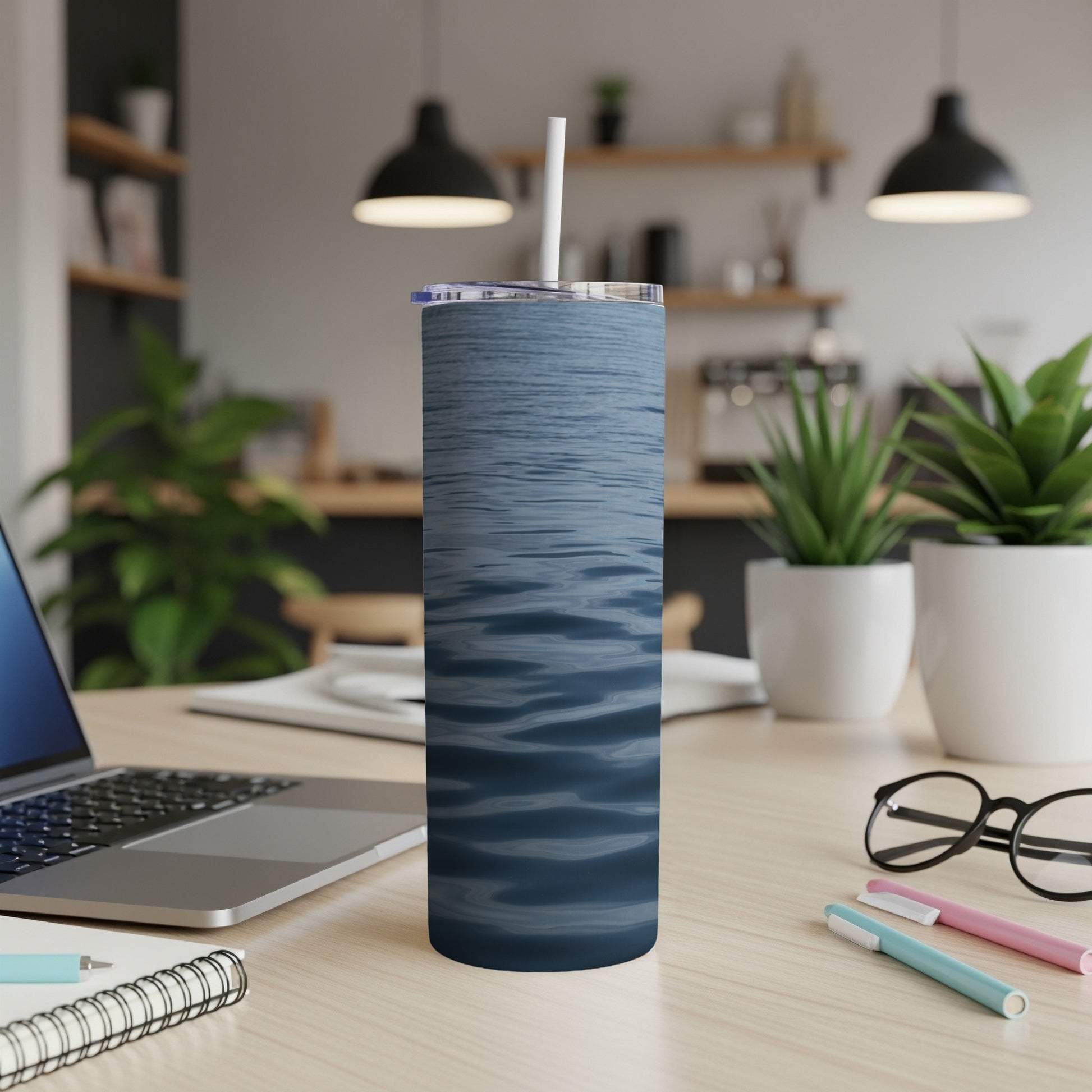 Blue wavy water pattern on a white tumbler with straw.