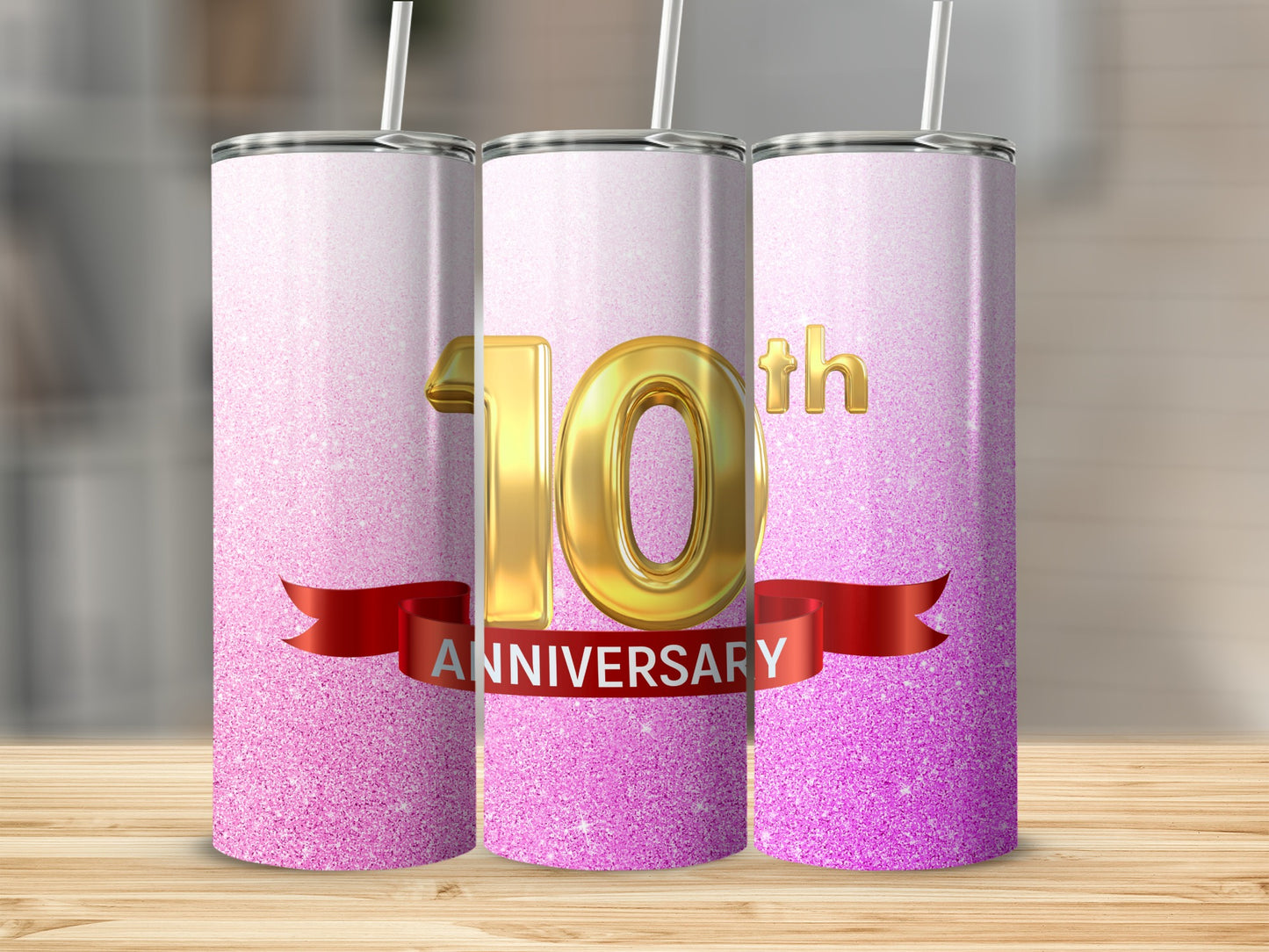 Gold "10th Anniversary" text on a pink glitter tumbler with a straw.