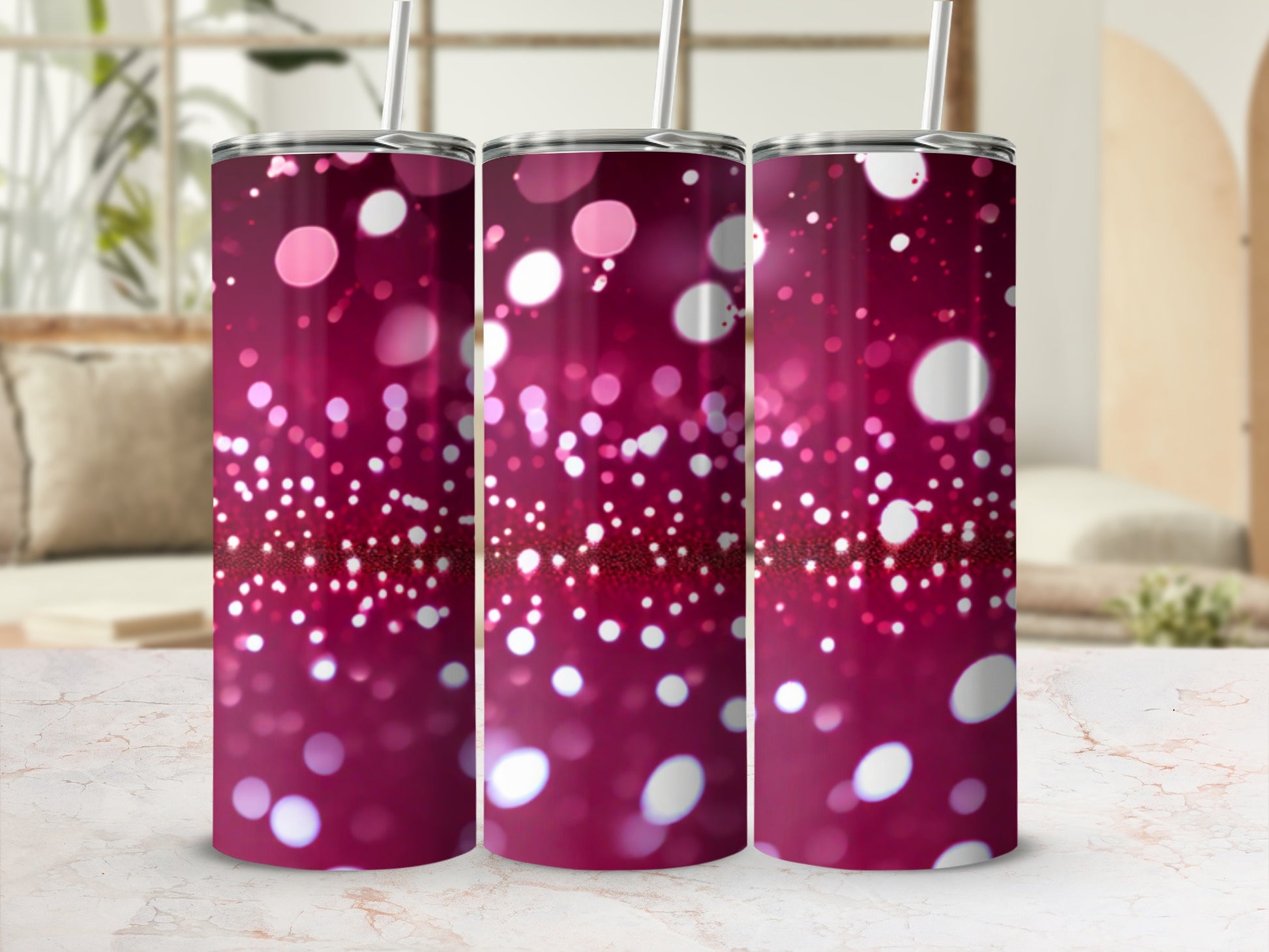 Three tumblers with a bokeh glitter design and metal straws.
