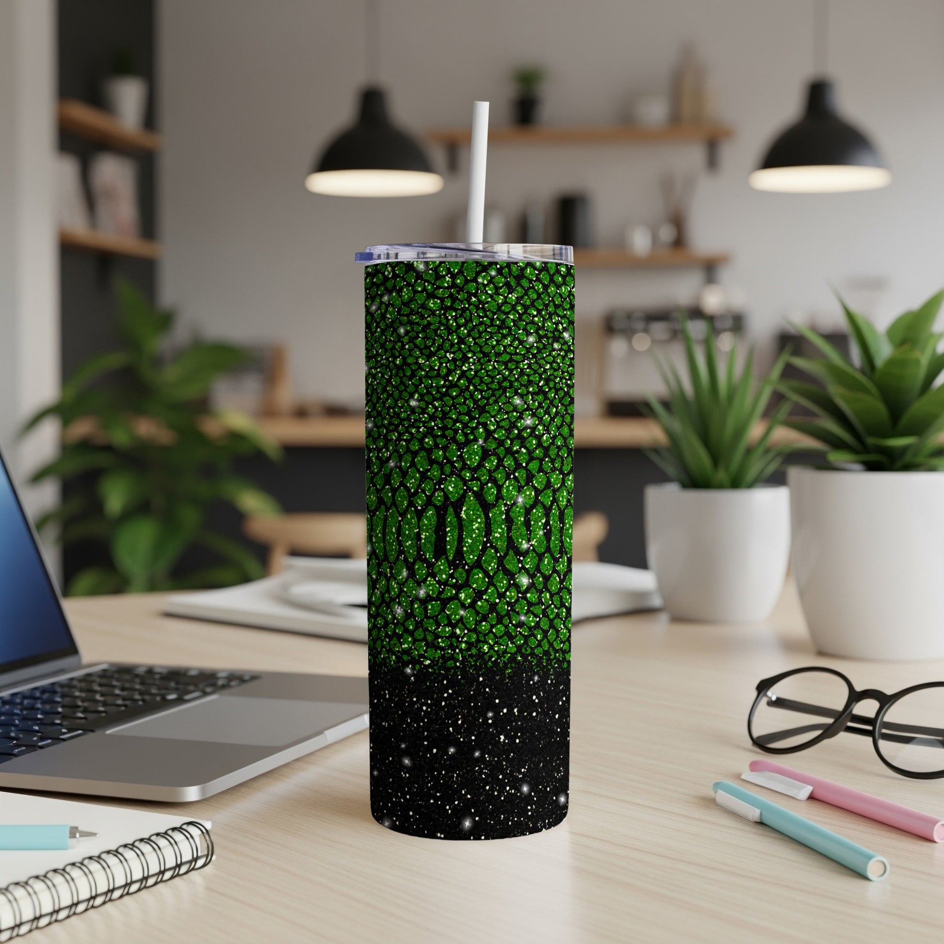 Green glitter tumbler with black speckles, straw, and white lid.
