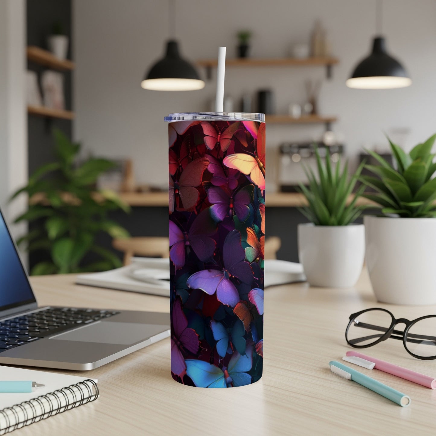 Tall tumbler with a vibrant butterfly pattern on a desk.