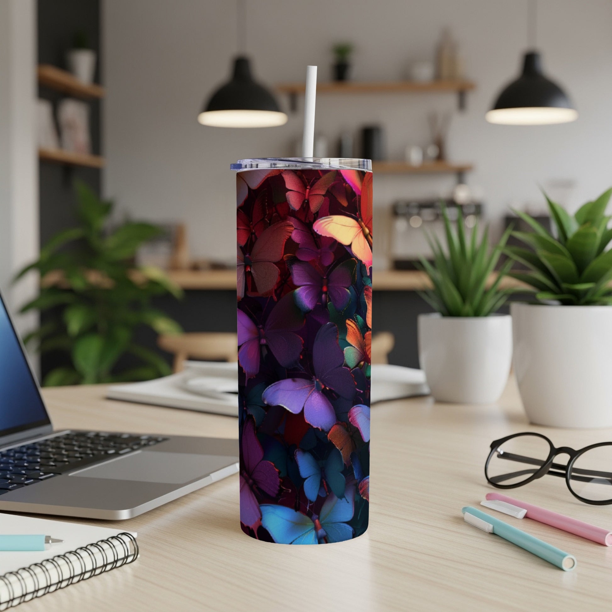 Tall tumbler with a vibrant butterfly pattern on a desk.