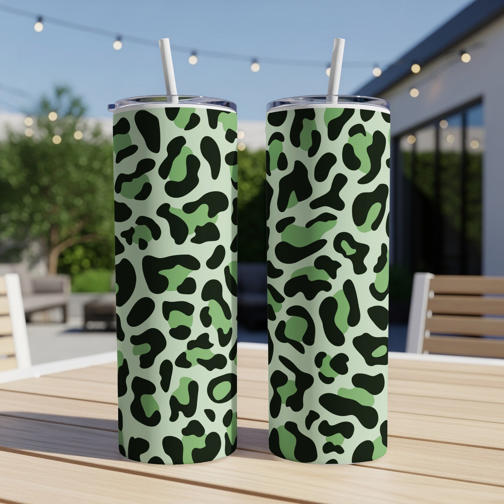 Two tall tumblers with green camouflage leopard print and white straws.