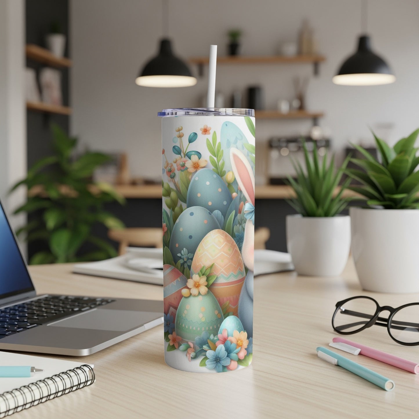 Easter eggs and bunny ears adorn a white tumbler with a straw.