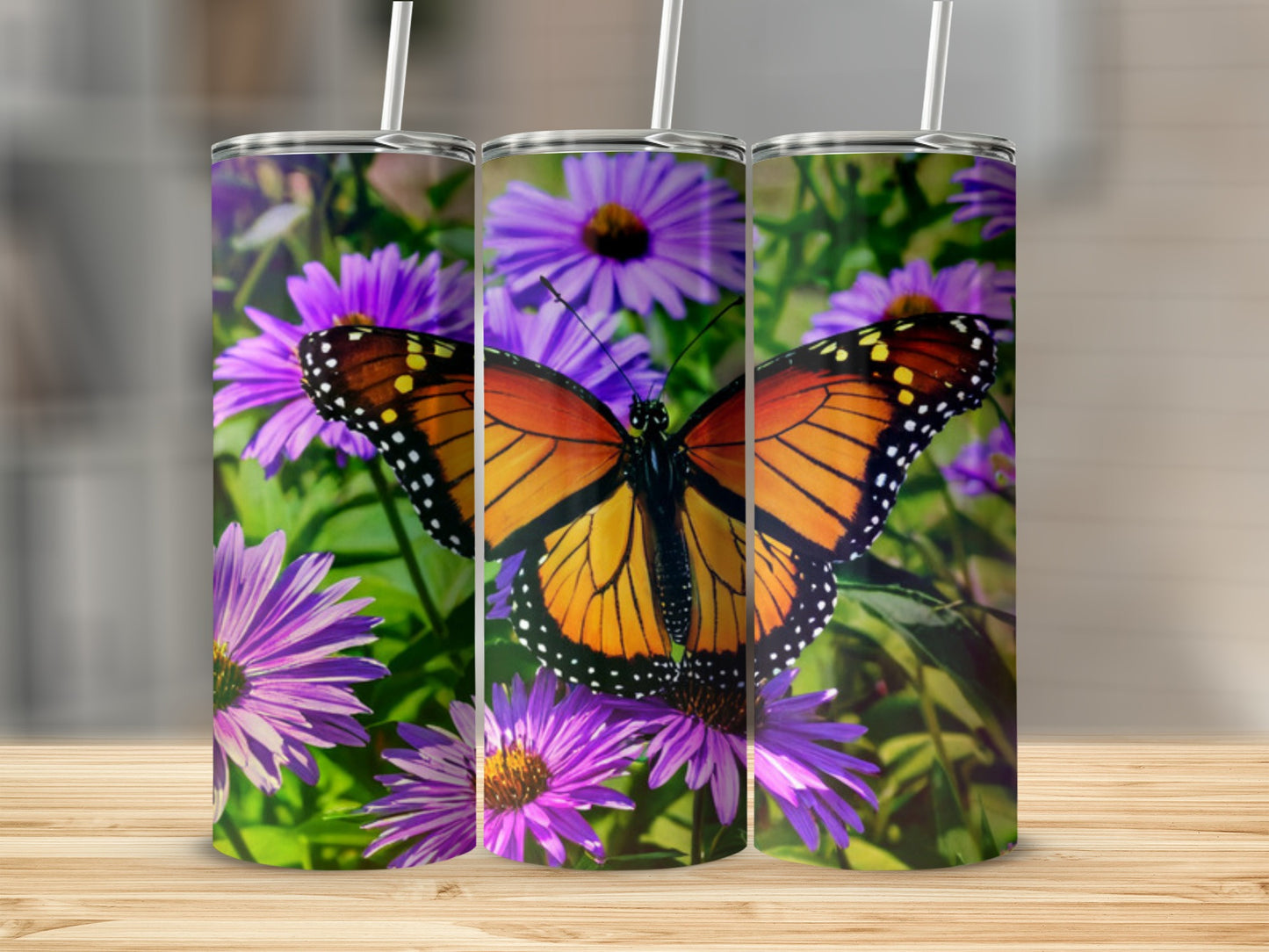 Monarch butterfly on purple flowers design on three tumblers.