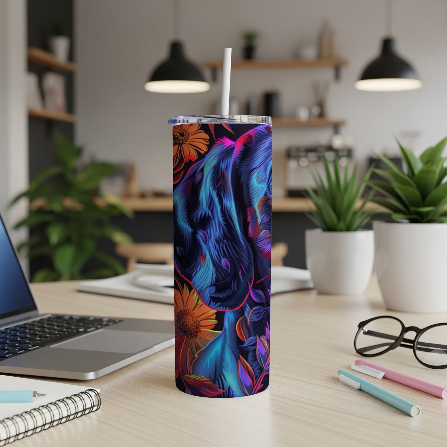 Blue and purple floral elephant design on a skinny tumbler with a straw.