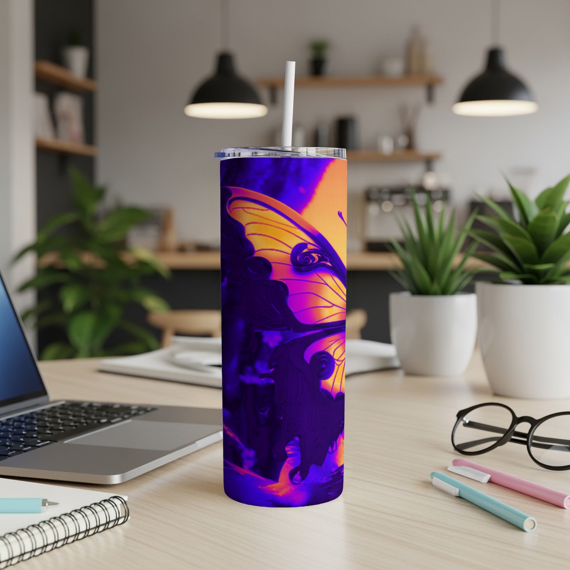 Tumbler with a vibrant purple and orange butterfly design on a desk.