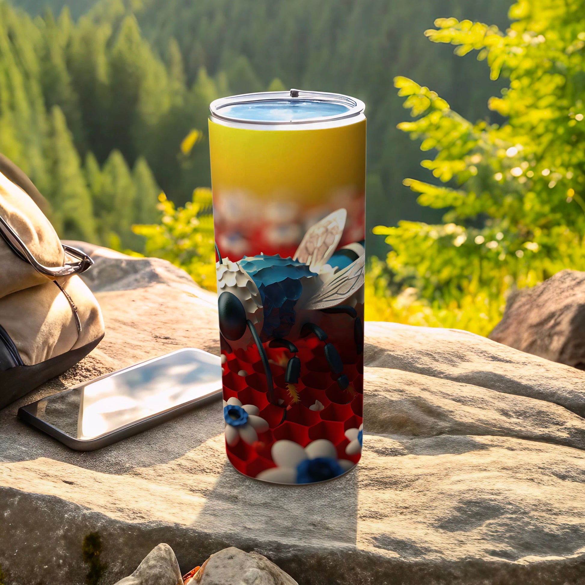 Tumbler with bee design on red and white floral pattern, outdoors.