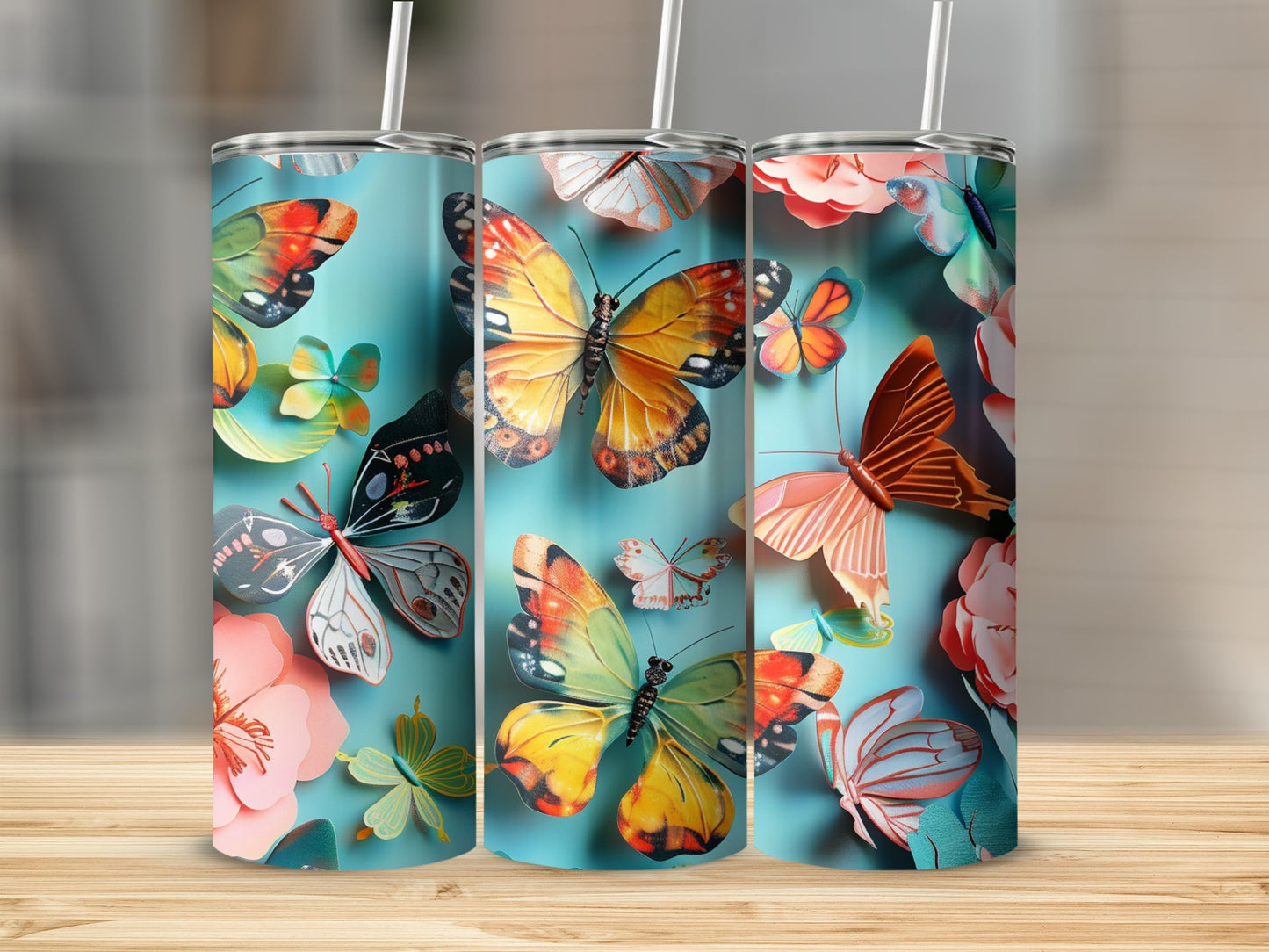 Three tumblers featuring colorful butterflies and flowers on a light blue background.