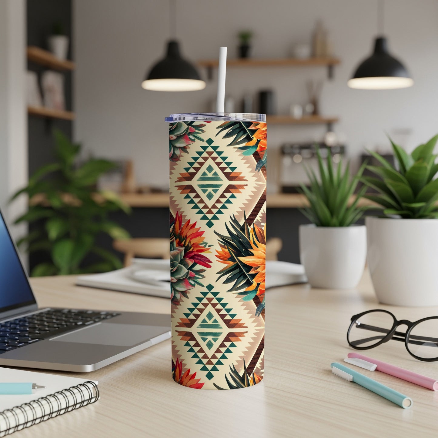 Patterned tumbler with geometric and floral desert motifs on a desk.