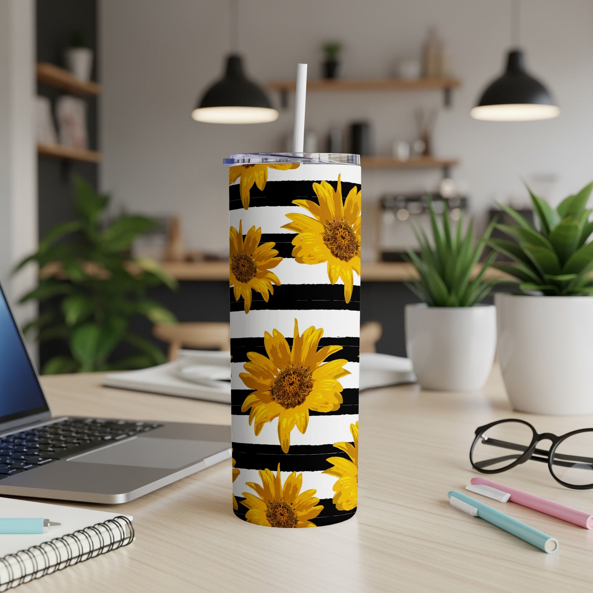 Tumbler with black stripes and yellow sunflowers, with a straw.