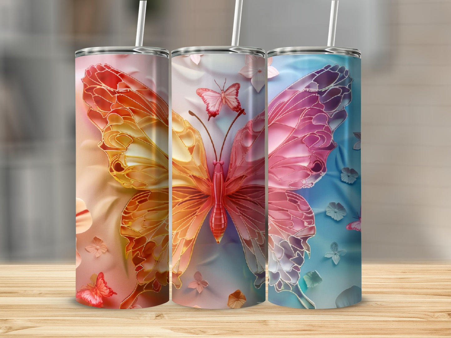 Three tumblers featuring iridescent butterfly designs in orange, pink, and blue.