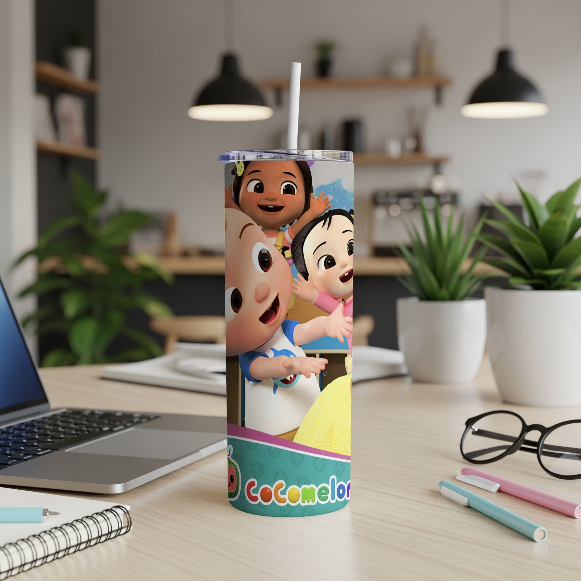 Cocomelon characters on a tall tumbler with a straw in a desk setting.