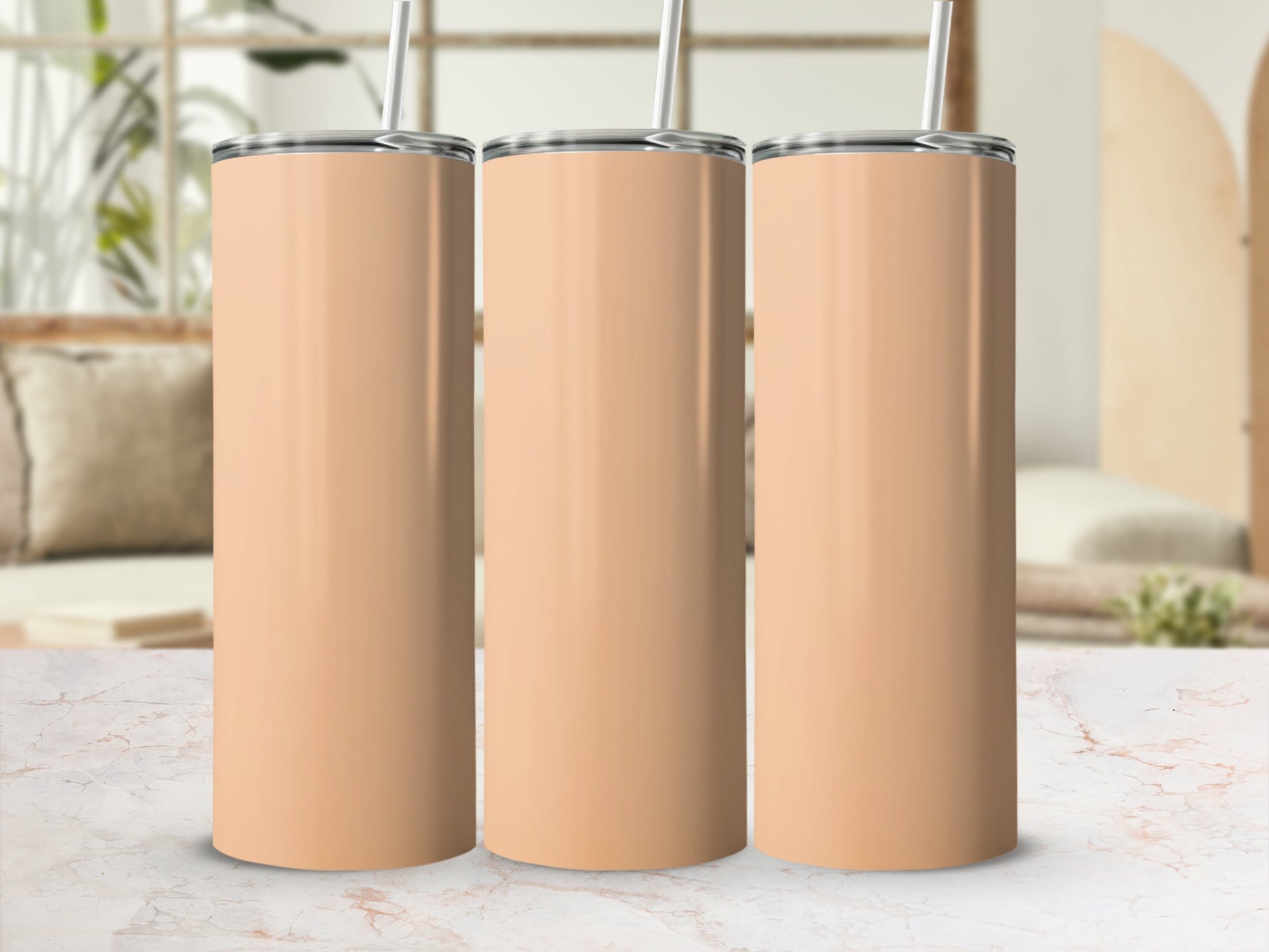 Three peach-colored tumblers with straws lined up on a marbled surface.