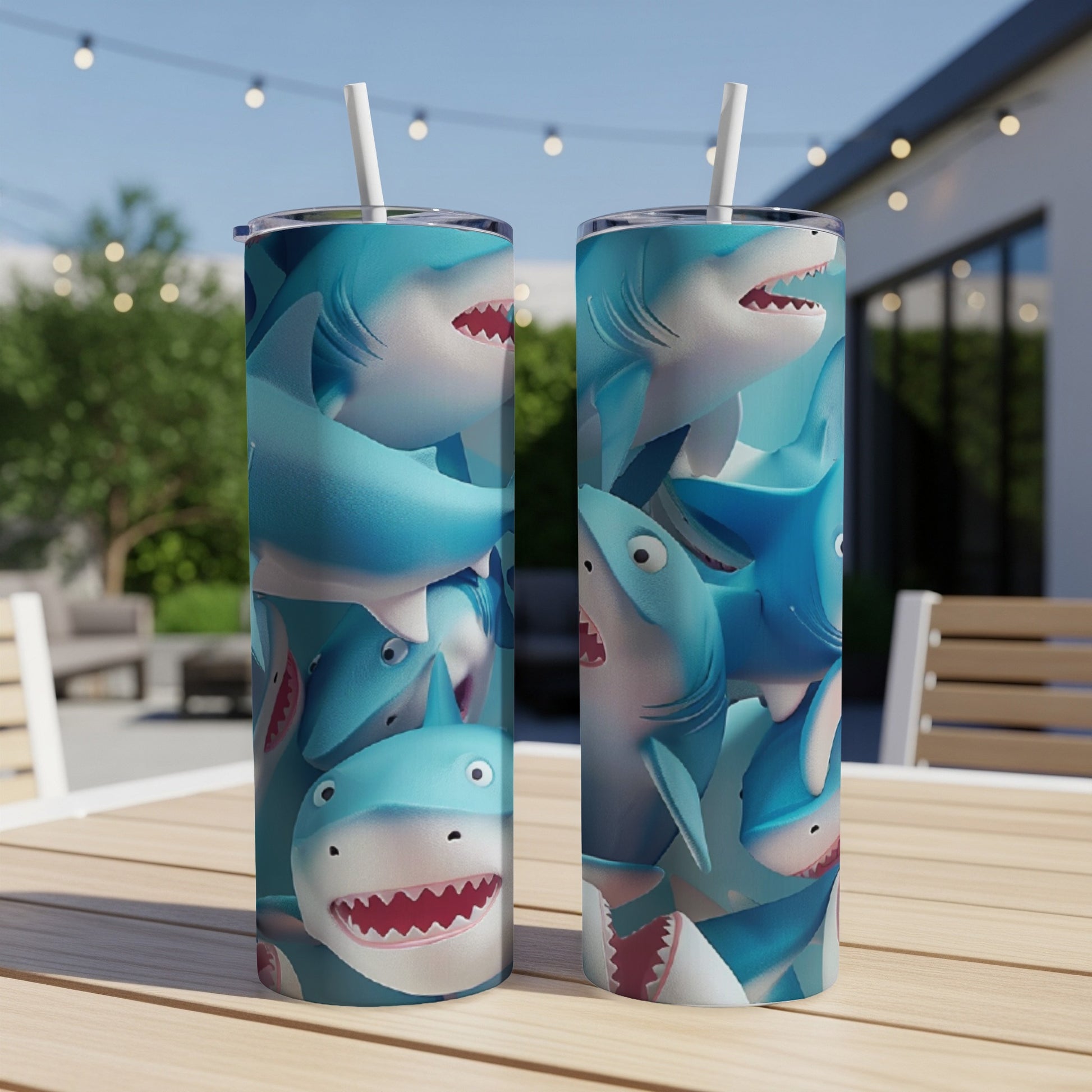 Two tumblers with a cartoon shark pattern on a wooden table outdoors.