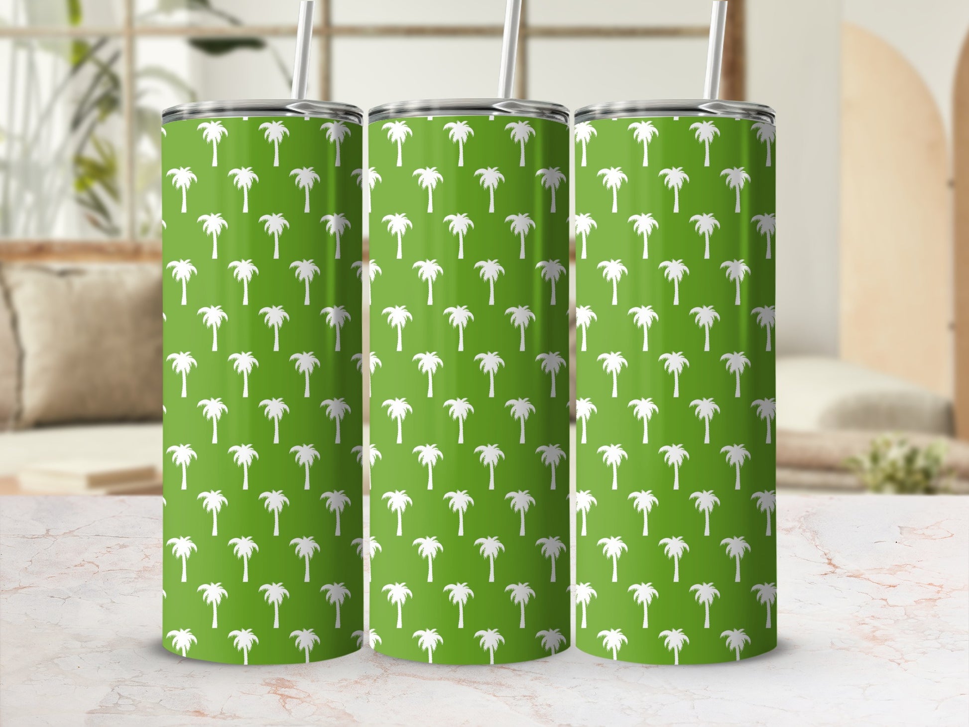 Three green tumblers with white palm tree pattern and reusable straws.