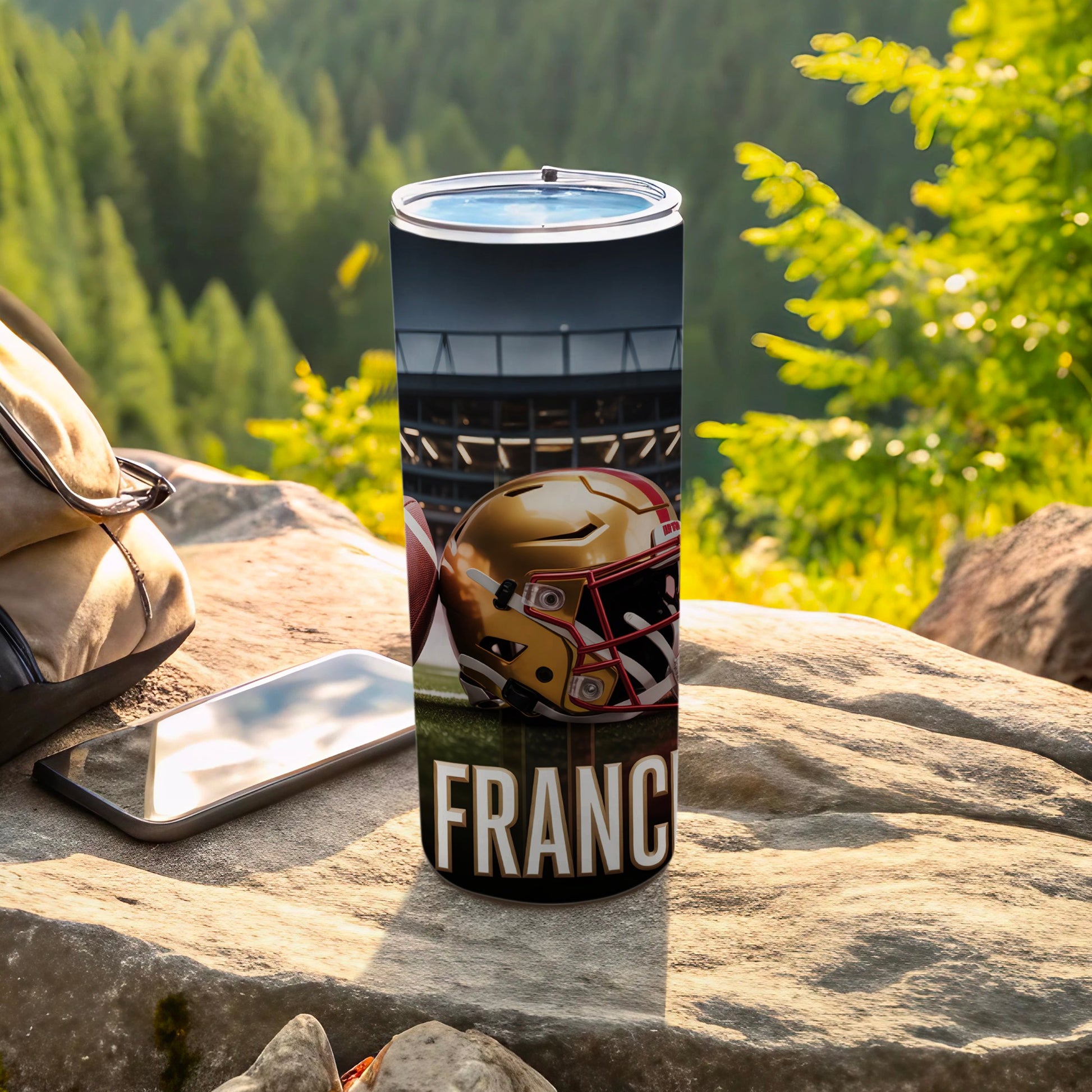 Football helmet and ball on tumbler with "FRANCE" text, outdoors.