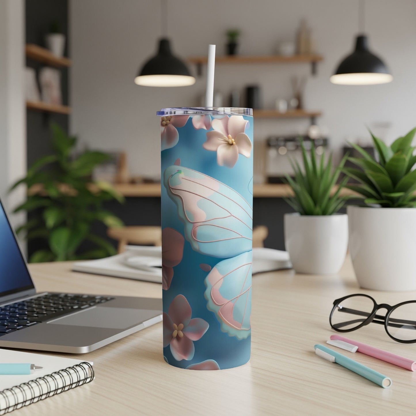Blue tumbler with pastel butterfly and floral design.