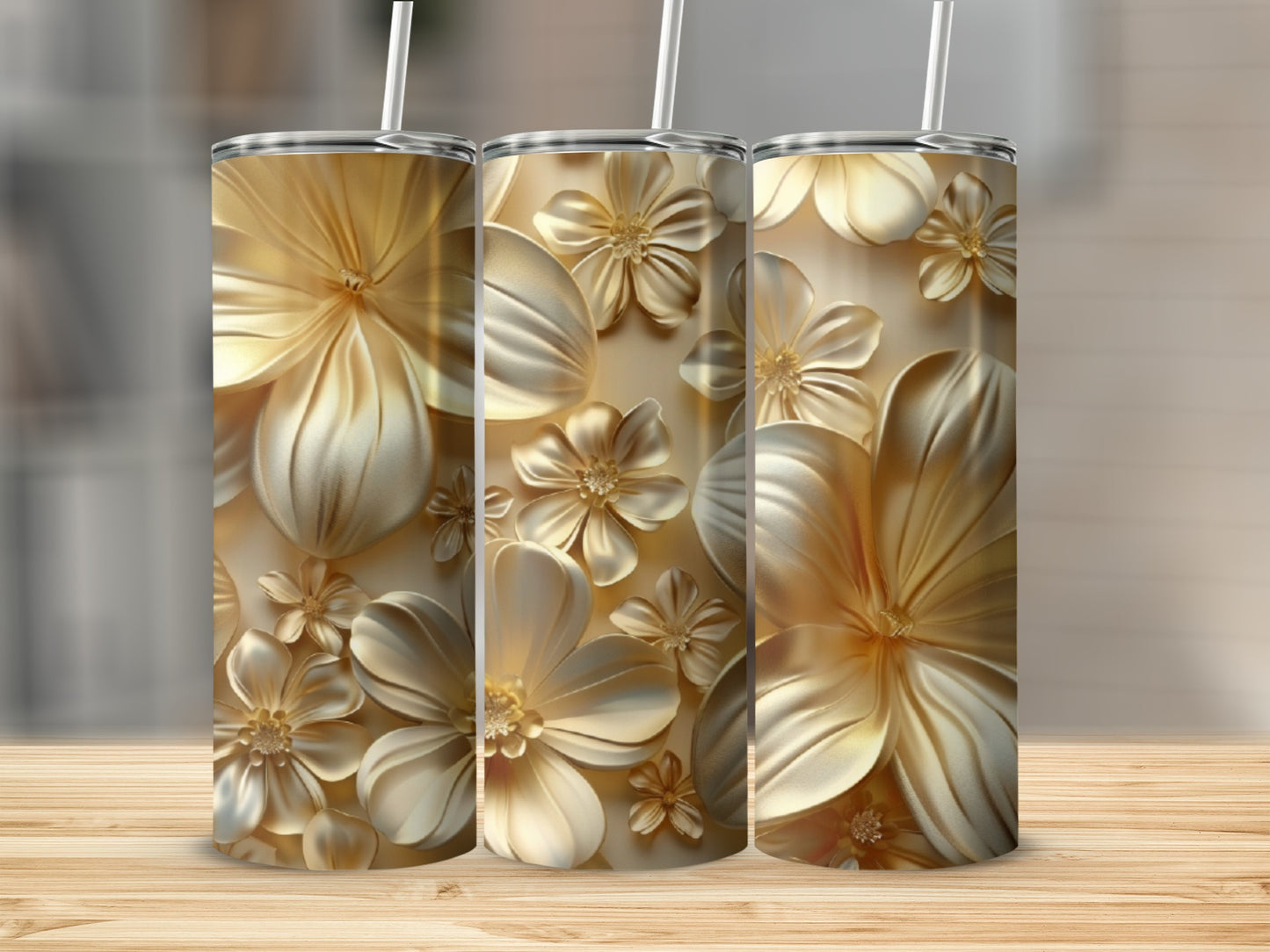 Gold floral pattern on three tumblers with white straws.